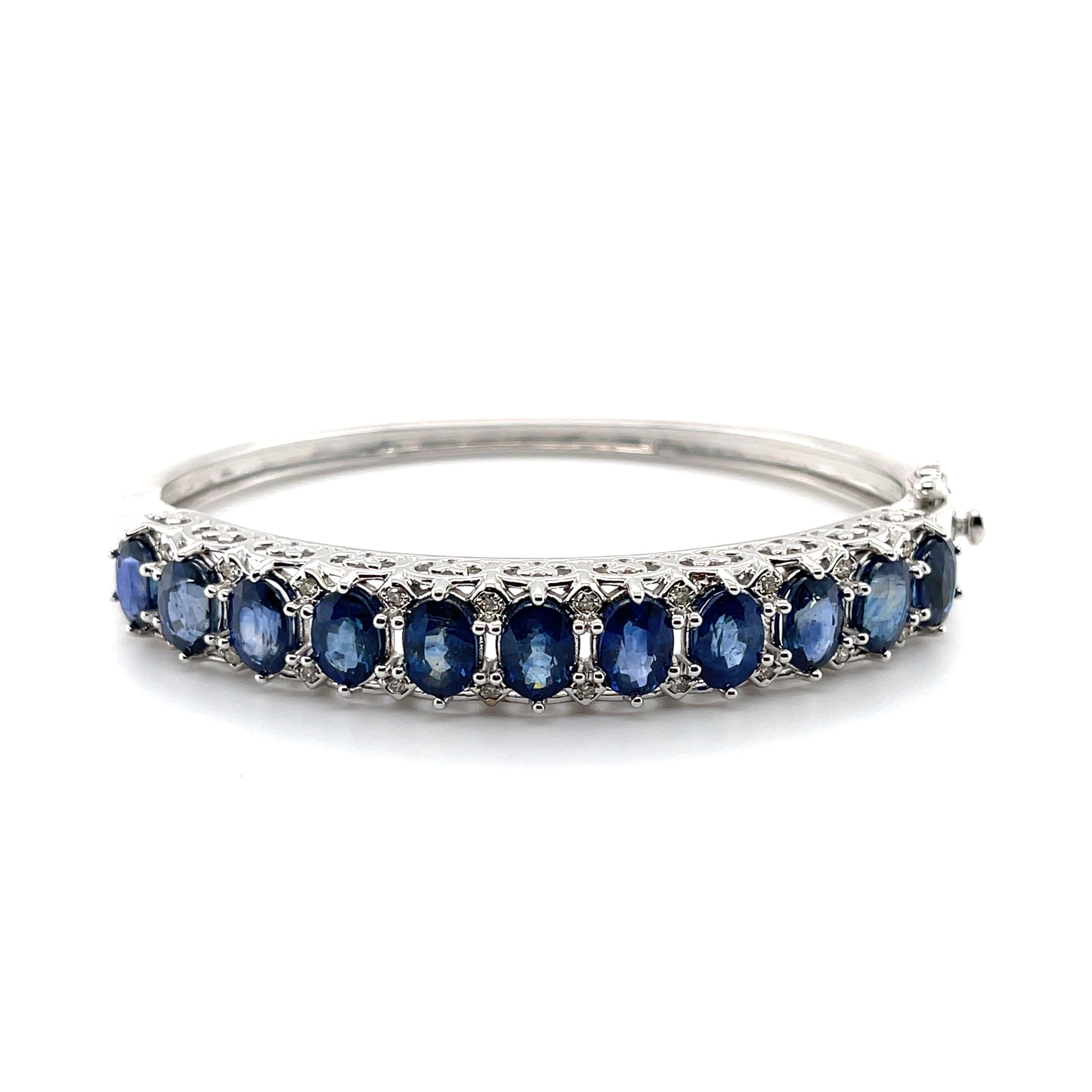 Oval shaped blue sapphires, crafted with Fourteen Karat white gold, featuring beautifully bead set round brilliant cut diamonds, complemented by a stunning polished finish design. 

Sapphire Weight: 13.80ct

Sapphire Colour: 