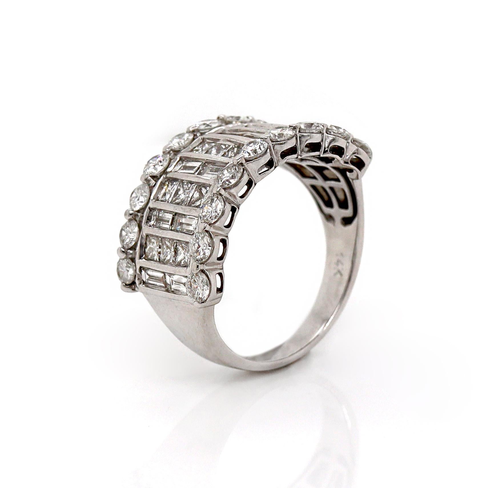 14ct White Gold Vintage Diamond Band Ring

This vintage diamond ring in 14ct white gold showcases a stunning array of round, princess, and baguette-cut diamonds, creating a beautifully intricate design. The centerpiece features a sparkling round