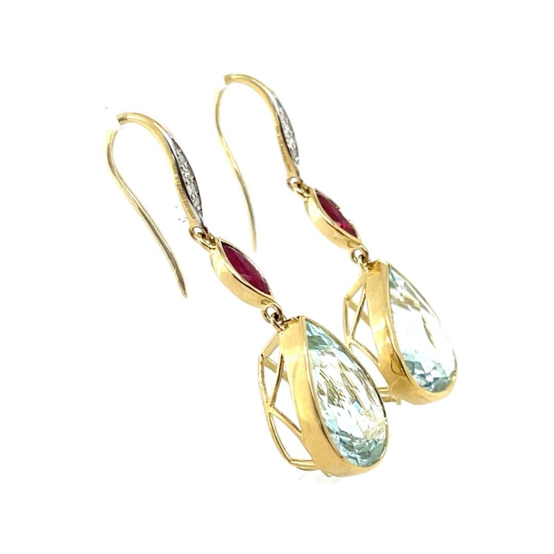 Gorgeous pair of Aquamarine , Ruby and Diamonds earrings, beautifully crafted in fourteen karat yellow gold , complimented by a stunning polished finish design.

Two Aquamarines, 11.68ct ctw, 15.03mm x 11.39mm x 6.71mm - 16.10mm x 11.57mm x 6.18mm