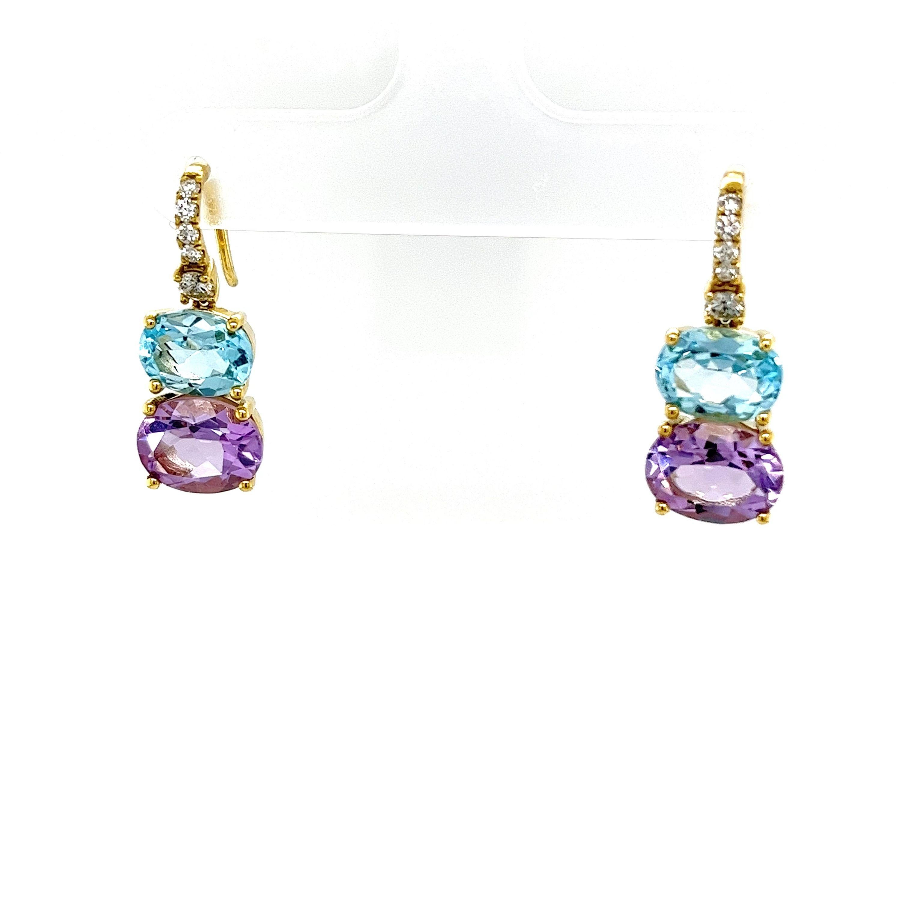 Arricchisci la tua collezione di gioielli con questi splendidi orecchini a goccia in oro giallo con topazio blu, ametista e diamanti. 
Questi squisiti orecchini mostrano la perfetta combinazione di gemme vibranti e diamanti scintillanti, creando un