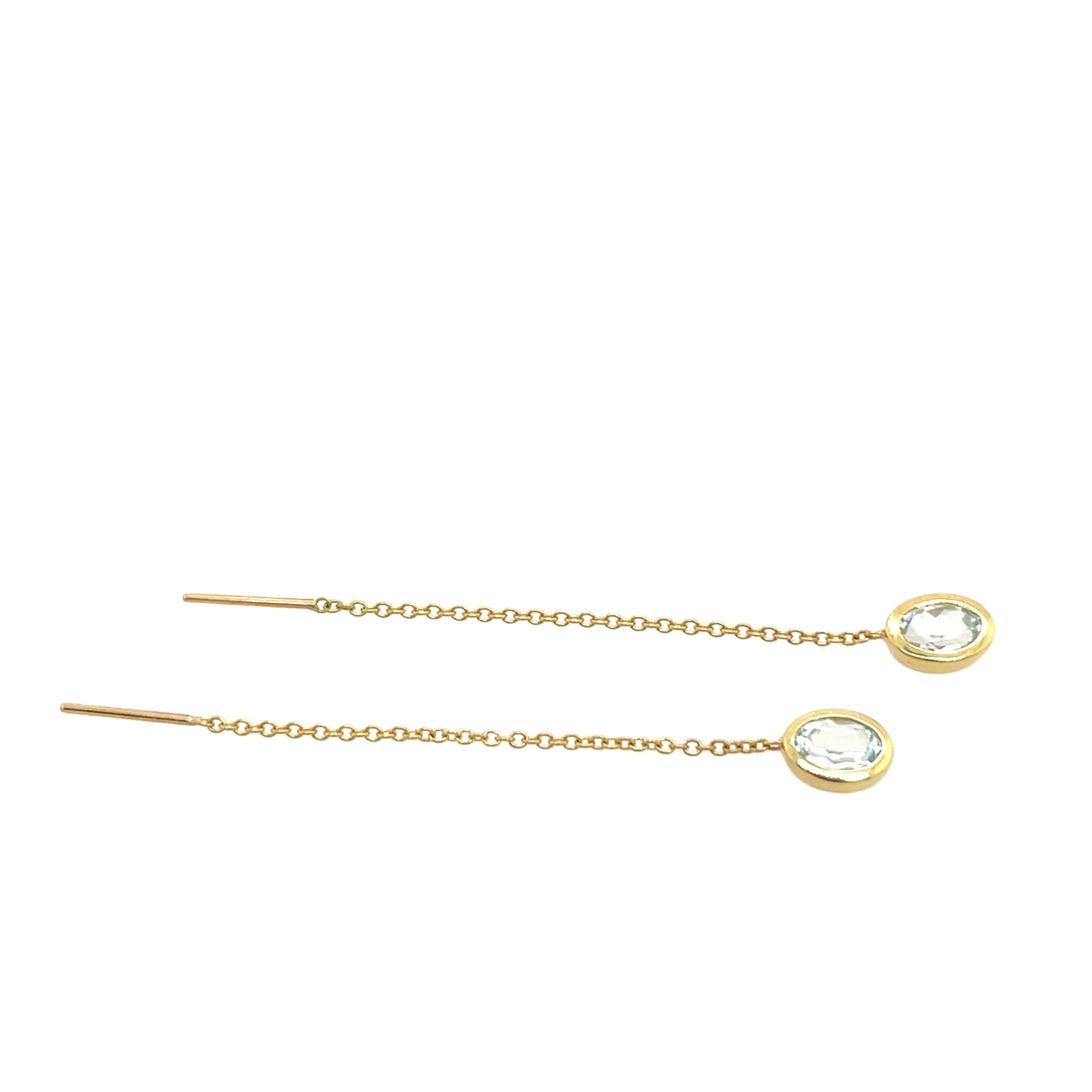 Preciosos pendientes de cadena de oro amarillo de 14 ct, engastados con 2 gemas ovales de aguamarina. Los relajantes tonos azules de las aguamarinas complementan a la perfección el cálido oro, 
creando un aspecto sereno y elegante. 

Peso total: