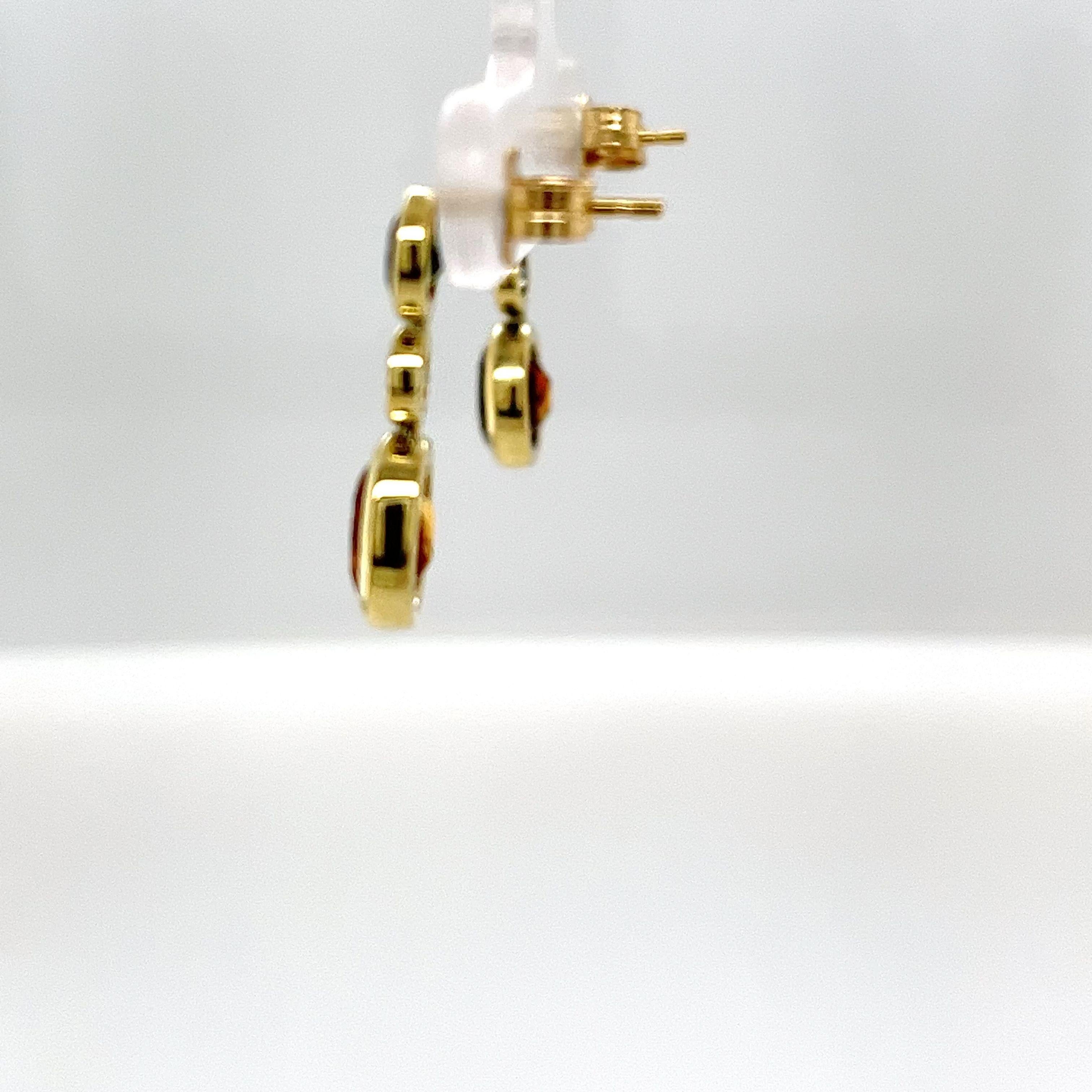 Enhance your jewelry collection with these stunning 14ct yellow gold drop earrings, featuring radiant citrine, vibrant green sapphires, and sparkling Diamonds. These exquisite earrings showcase a harmonious blend of warm and cool tones, creating a