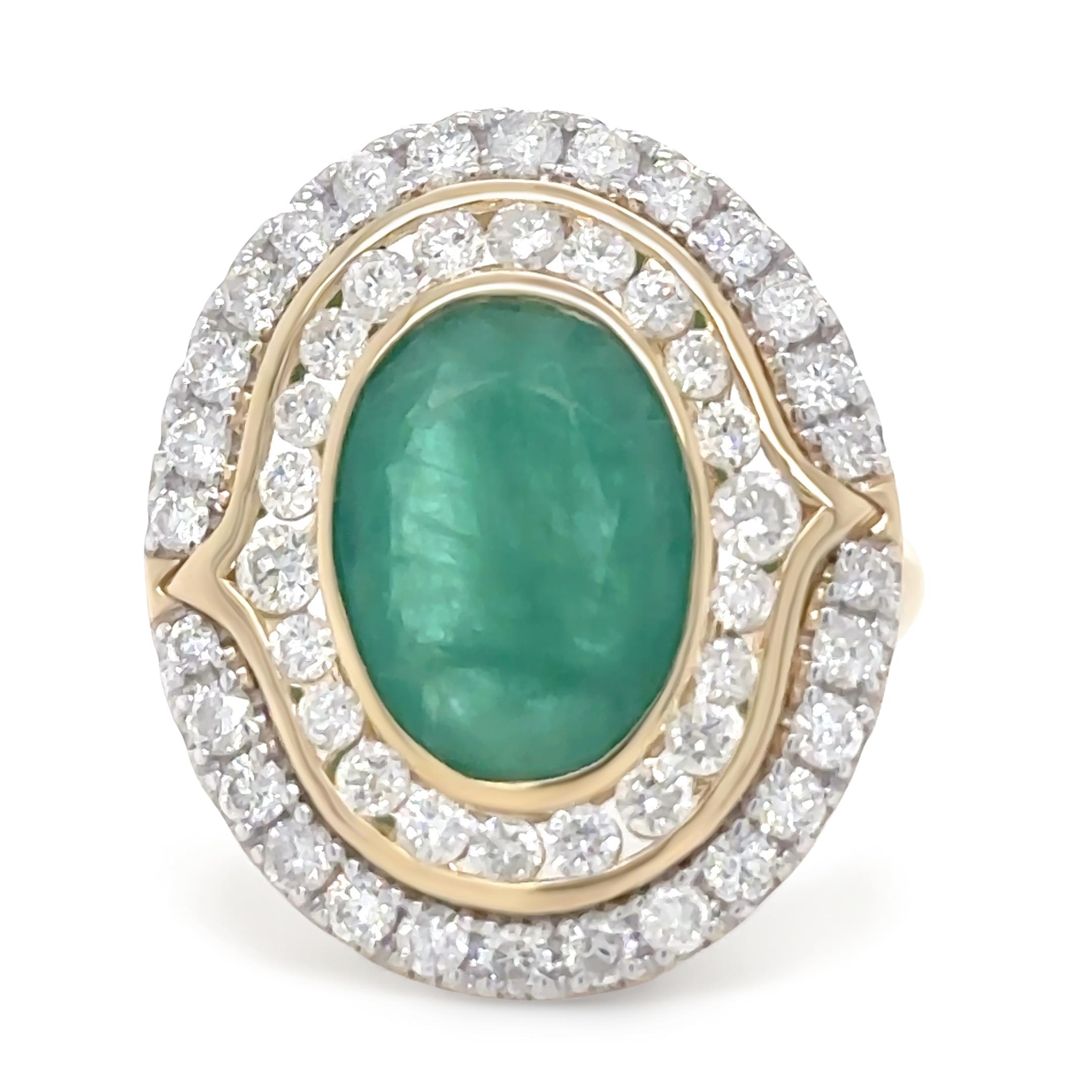 A luxurious 14ct yellow gold and rhodium-plated ring, featuring a timeless double halo design. This piece showcases a stunning 4.00ct oval-cut emerald with a dark green hue and moderate inclusions, securely bezel-set in a filigree