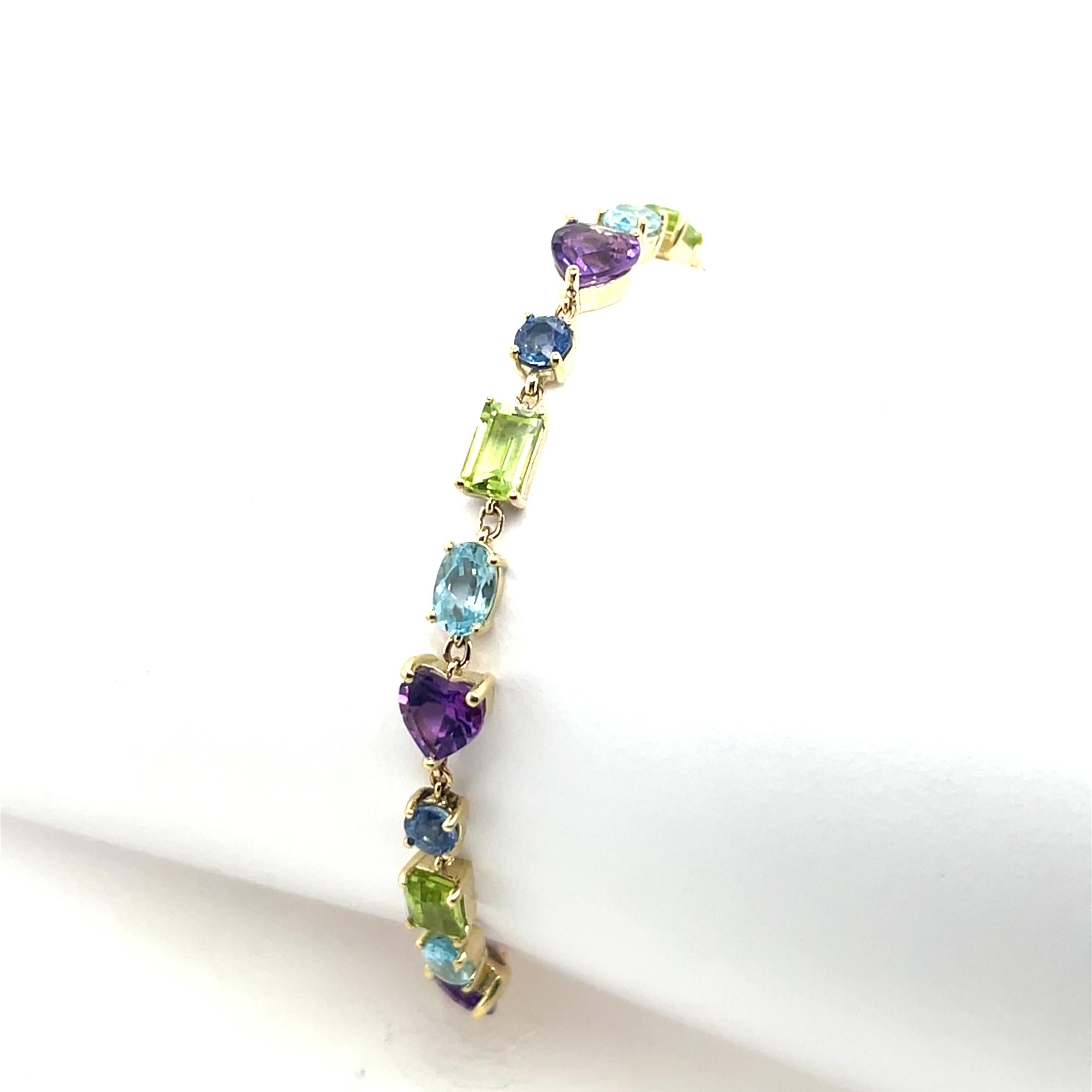 A stunning 14ct yellow gold bracelet, beautifully set with an array of vibrant amethyst, peridot, aquamarine, 
and blue topaz gemstones. 
The combination of these semi-precious stones creates a colorful and elegant design, 
perfect for adding a