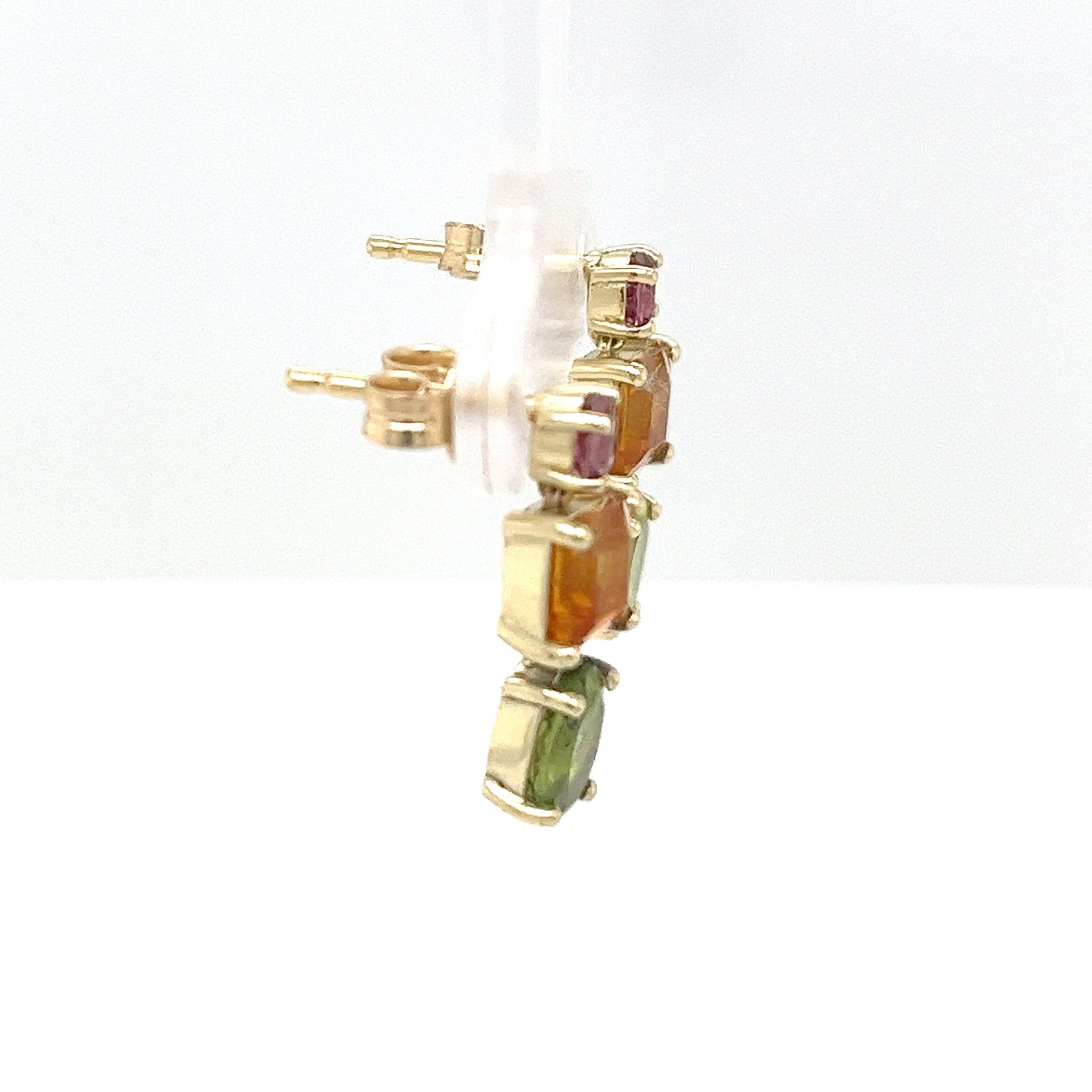 Chic et colorées, ces boucles d'oreilles pendantes en or jaune 14ct 
sont sertis de saphirs roses vibrants, de citrines chaudes et de péridots verts luxuriants, offrant un contraste et un éclat vivants. 
Parfait pour ajouter une touche de couleur