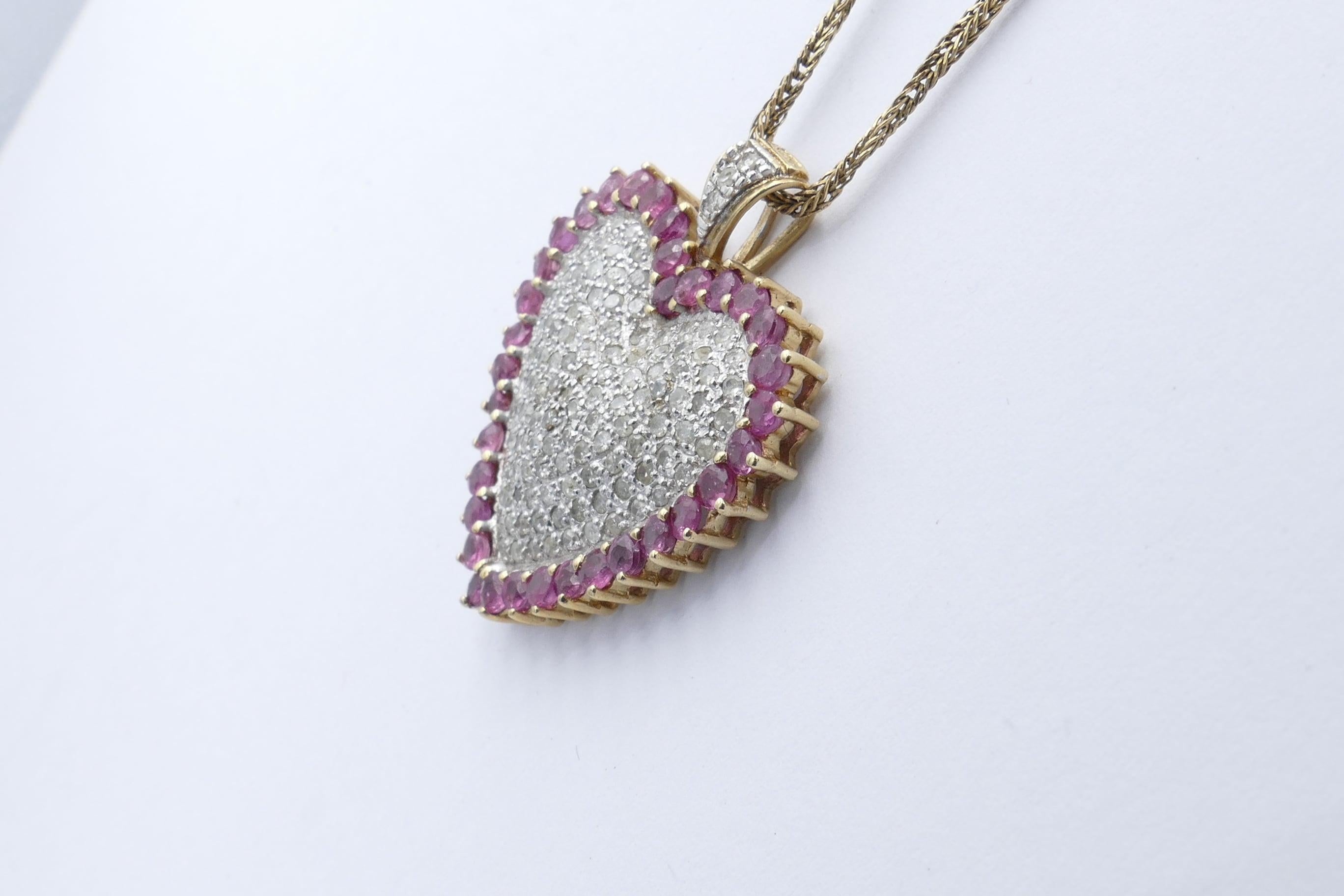 34 lovely Rubies surround this Heart Shape very pretty Pendant, round cut, bead claw set. 
Inside this are 129  round single cut Diamonds, grain/pave set over White Gold and weighing just on 1.10 carats.
The pendant measures 33mm X 28mm inclusive of