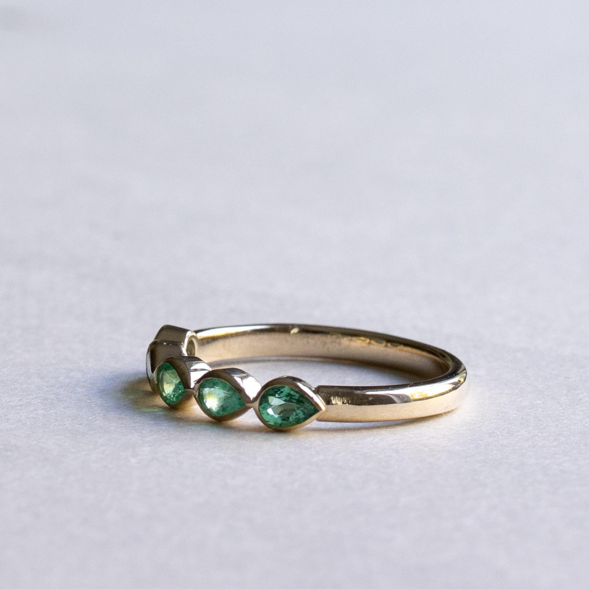Tear drop emerald line up on this 14k yellow gold

Metal: 14k yellow gold
Stone: Natural emerald
Stone Shape: Pear
Stone Size: 3mm x 4mm
Total carat weight: 0.5 carat
Band Width: Approx 2mm
