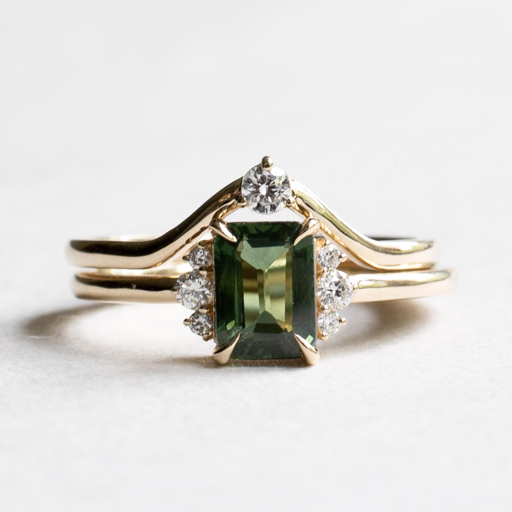 Green sapphire adorned with diamond accents. Set of two rings
Metal: 14K Yellow Gold
Stone: Green Sapphire
Stone Weight: 1 Carat 
Accent Stone: Round Diamond
Diamond Color and Clarity: GHI, VS
Stone Size: 1.25mm(4), 2mm (2), 2.5mm (1)
Total Diamond