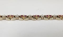 Bracciale in oro 14k a due toni con rubini ovali e diamanti, contenente 25 rubini ovali di gemma