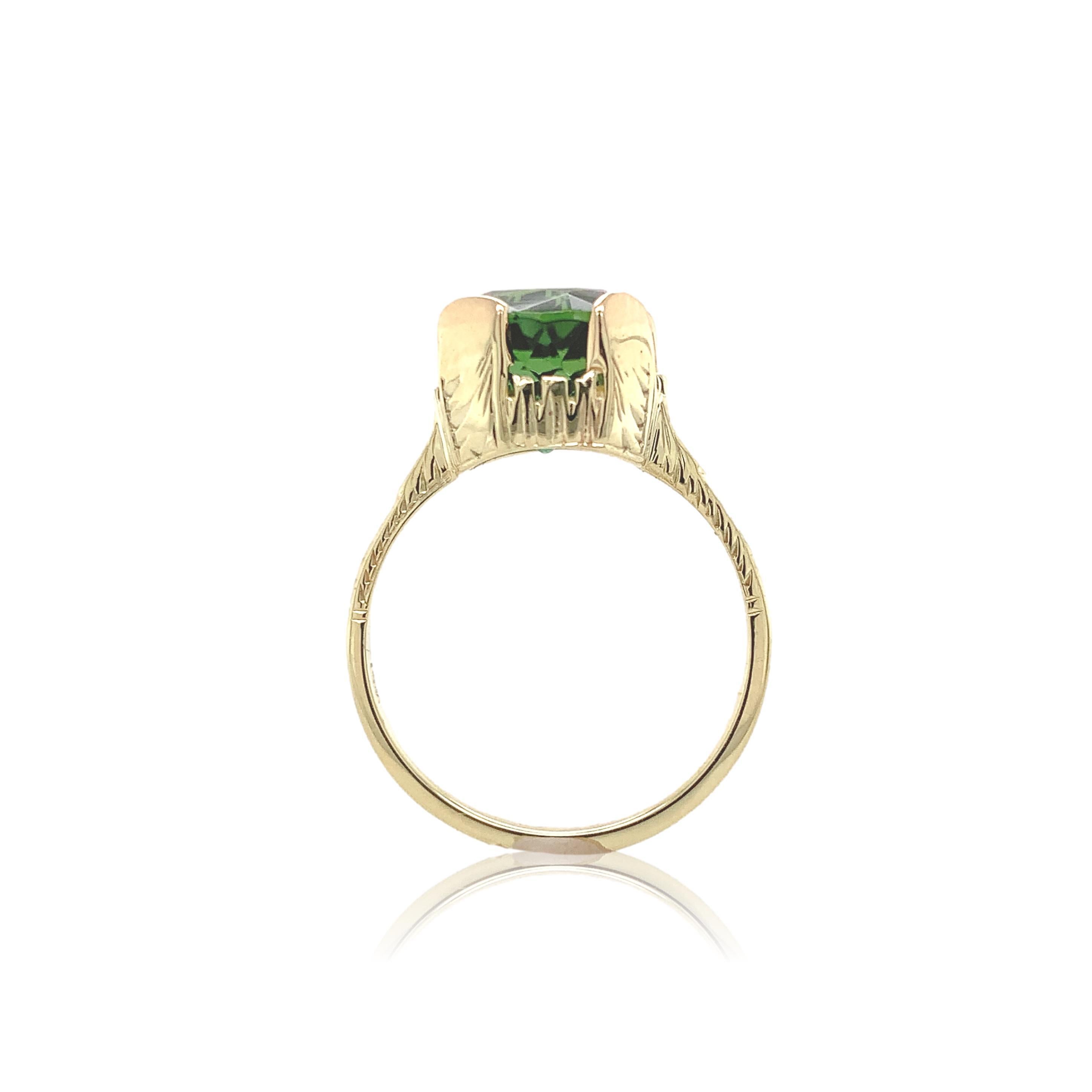 14K yellow gold ring featuring a green tourmaline. The round brilliant cut tourmaline weighs 2.94 carats and measures about 8.2mm. There is hand engraved detail and 4 new prongs. The ring fits a size 5.25 finger, weighs 1.76dwt. and dates from the