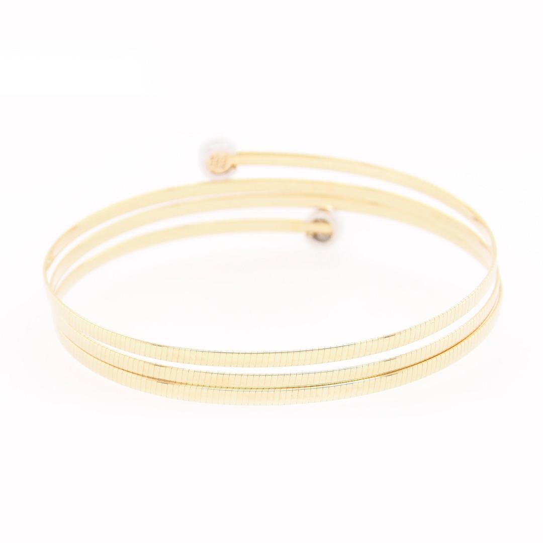 This is a great 14K Yellow Gold 4 Band Wrap Bracelet with Diamond Bezel Ends.  Set with (14) Round Brilliant Cut Diamonds G-H in color, VS-SI in clarity and approximately 0.14 carat total weight.  A delightful Bangle that is flexible and wraps