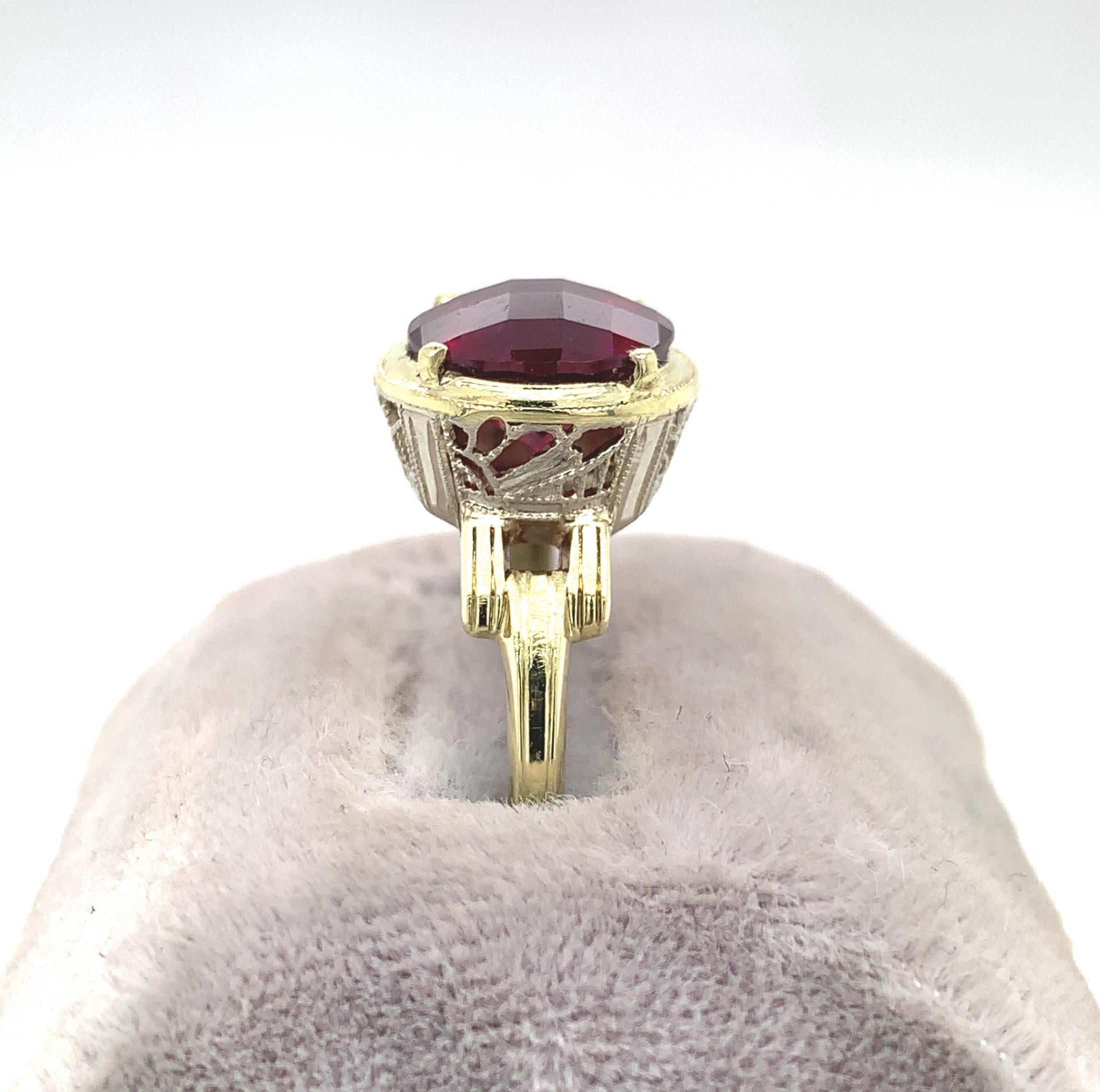 14K yellow gold ring with white gold filigree set with a large round rhodolite garnet. The garnet weighs 4 1/2 carats and measures about 10mm. The garnet has raspberry darker pink color with a specialty checkerboard top. The ring fits a size 8.5