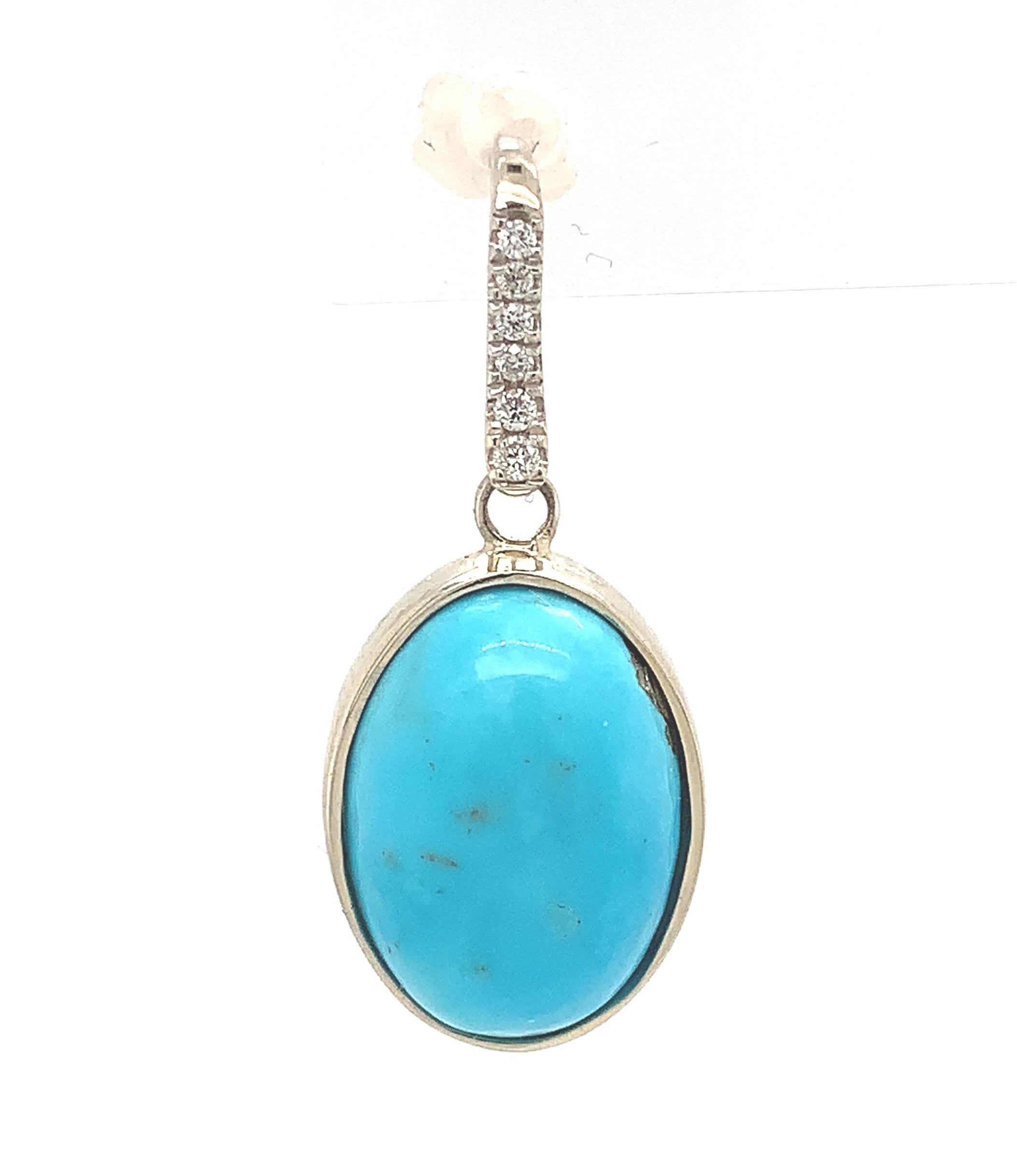 
 14K white gold pair of turquoise and diamond drop earrings with wire hooks. This is Kingman turquoise from Arizona, which is the last full-time production mine in the US. The oval turquoise measures about 14mm x 10mm and weighs 9.17 carats total.