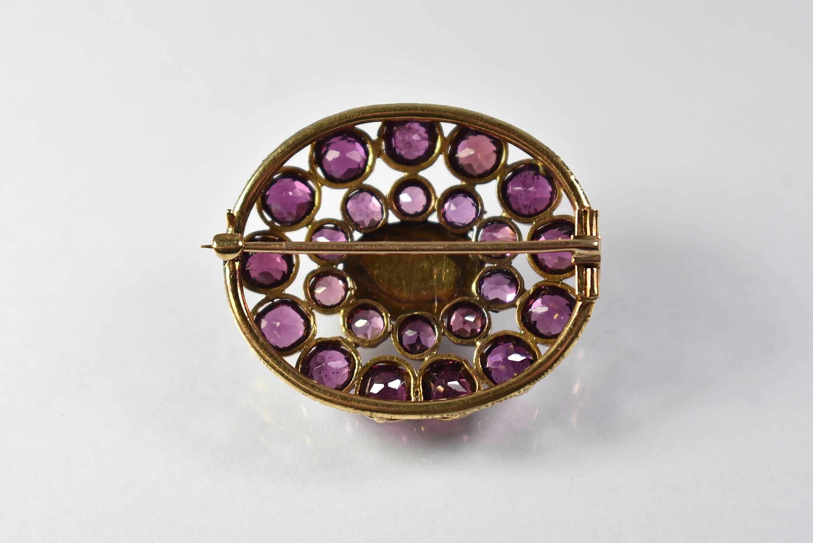 A stunning Almandine Garnet Victorian era brooch. This stunning piece features a centre cabochon surrounded by 22 facetted round stones. It has been test as 14-karat. It is 1 3/8