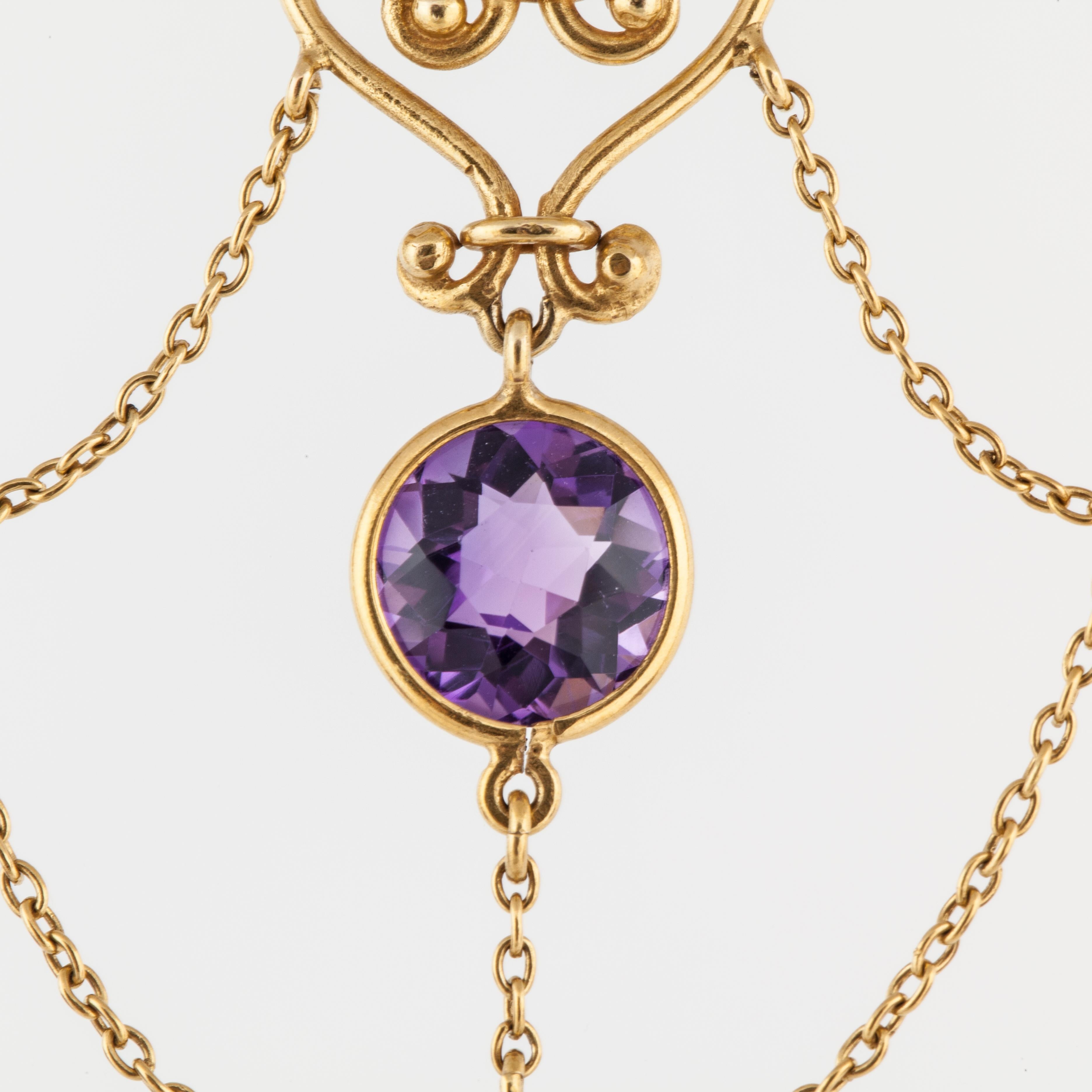 Swag necklace in 18K yellow gold featuring round amethysts with a seed pearl accent.  There are nine bezel-set amethysts that total 11 carats.  There is also one small seed pearl in the center.  The necklace measures 14 1/2 inches long and hangs 2