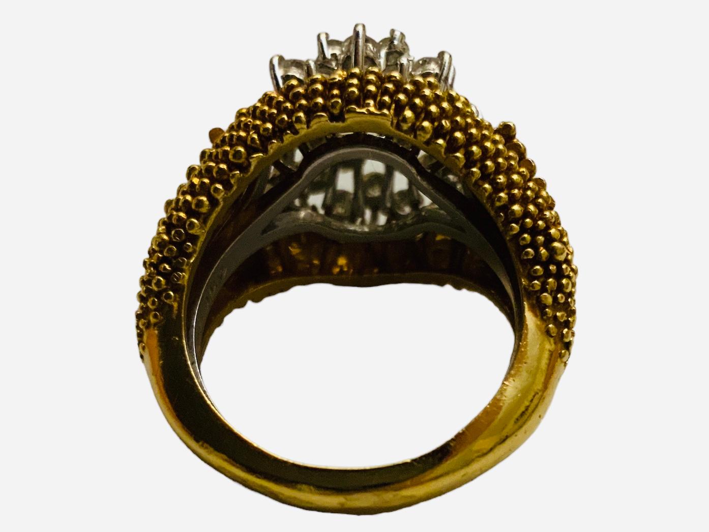 This is a 14K and 18K Gold and diamonds ring. It depicts  a 18K yellow gold wide ring (weighing 6.8dwt  ) made of a cluster of beads that serves as an insert to an 14K white gold ballerina diamonds ring (weighing 2.5dwt ). This white gold ring