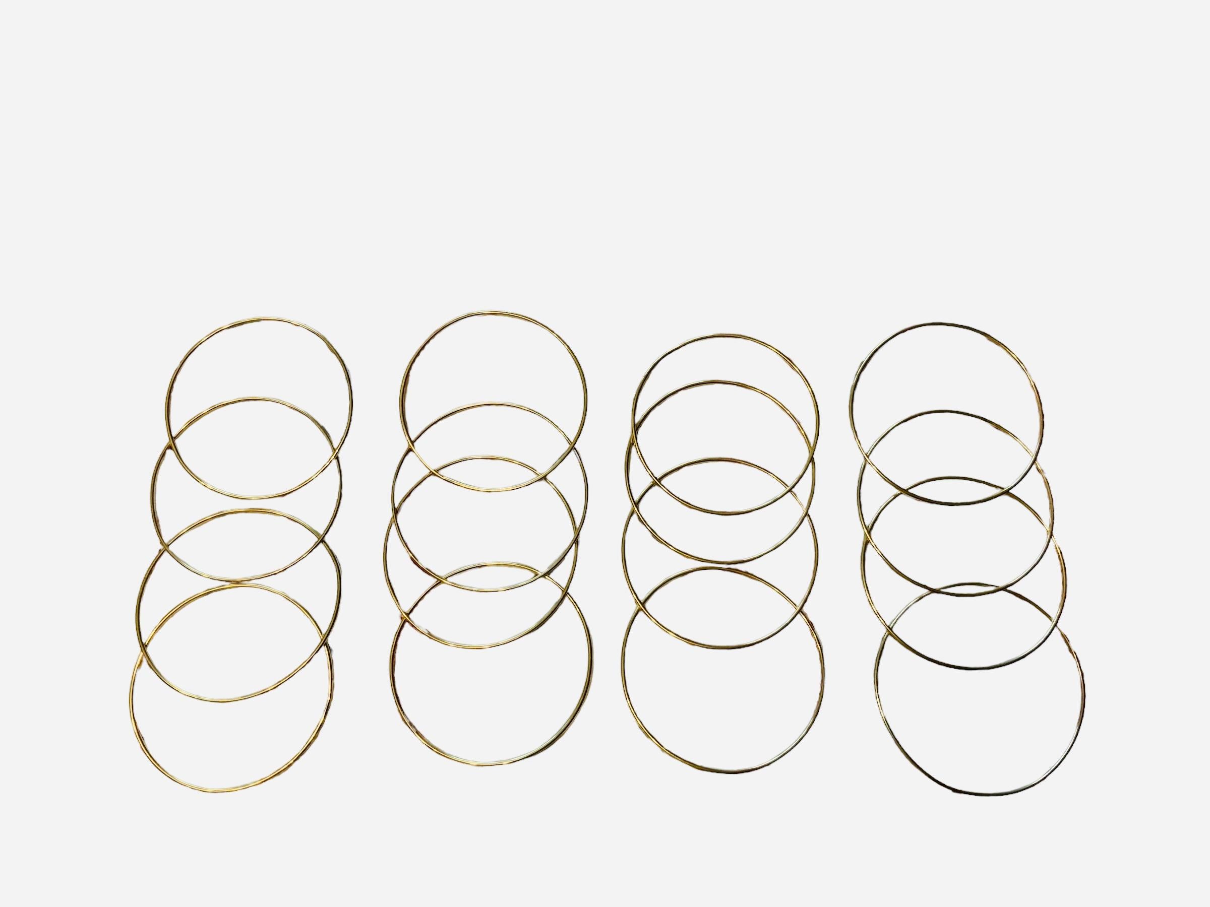 This is a cluster of  14K and 18K yellow gold bangles. It depicts a bundle of thin solid tubular bangles.