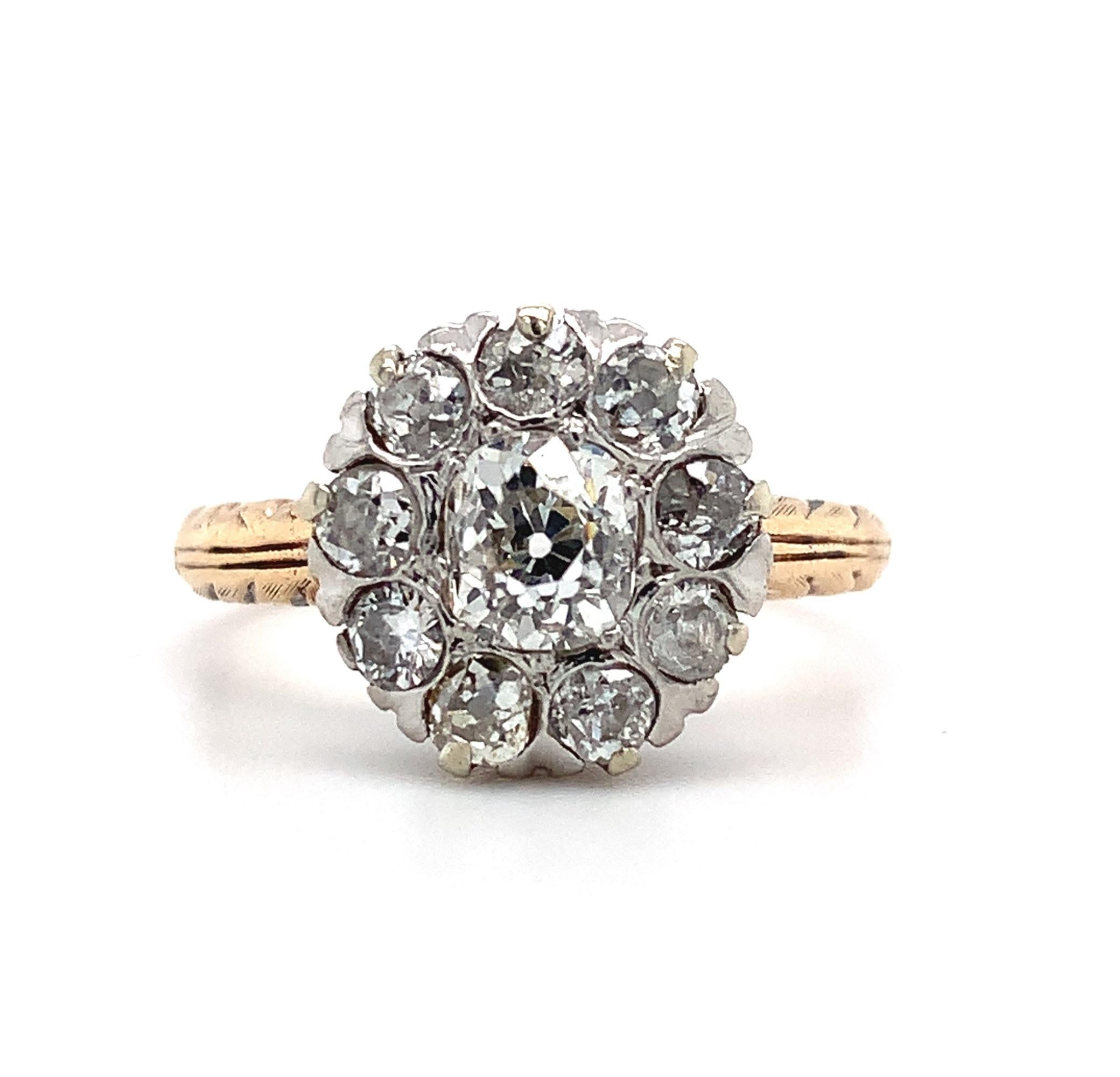 
14k yellow gold Victorian diamond ring with about 1.02 carats total weight of antique mine cut diamonds set in a platinum top. The center diamond measures about 4.5mm and the 8 surrounding diamonds measure about 2.5mm each. The diamonds have with