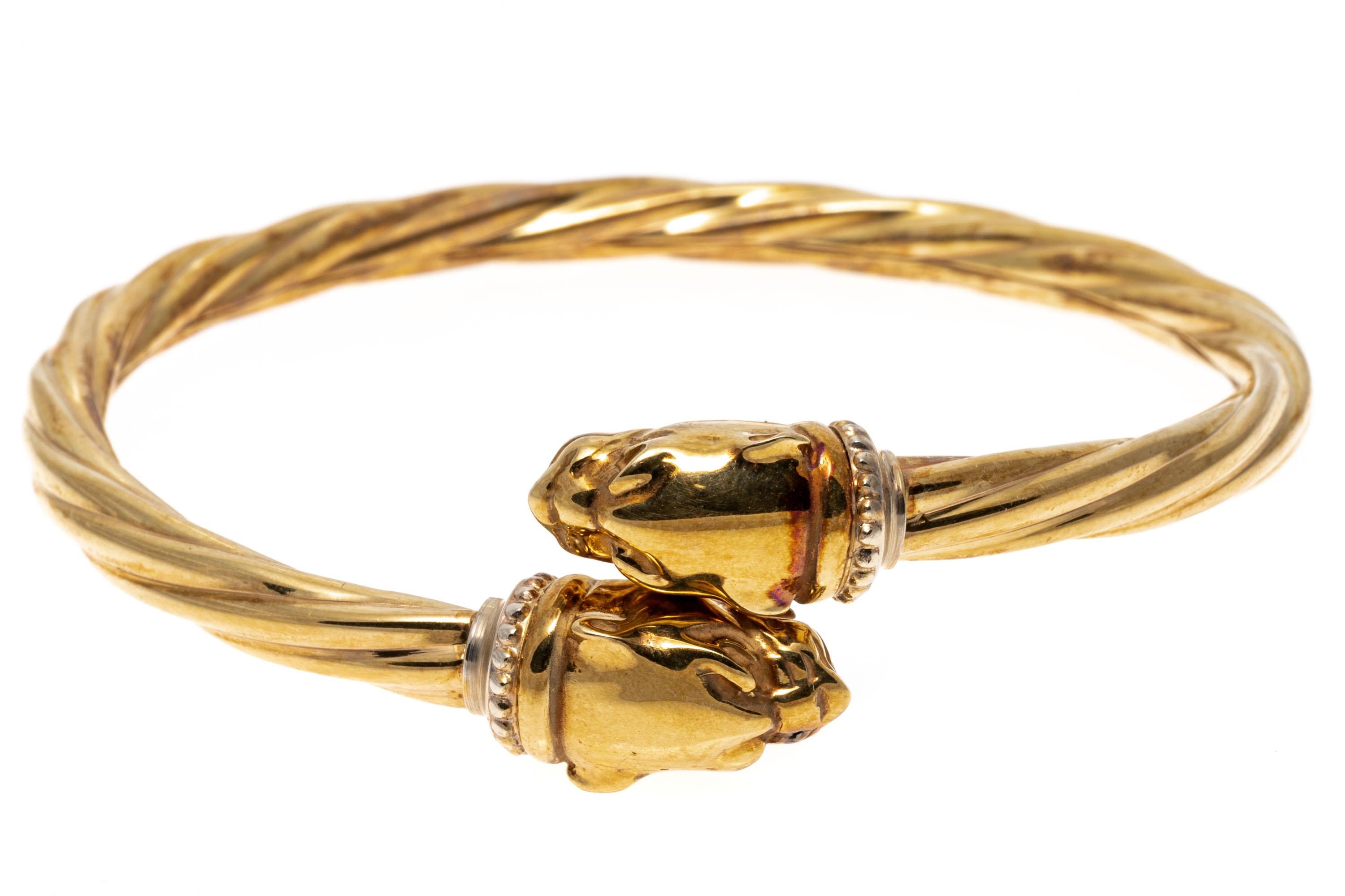 14k yellow gold bracelet. This stylish ribbed bypass style bangle bracelet features opposing roaring panther heads, decorated with yellow gold and sterling beaded collars.
Marks: 14k, sterling
Dimensions: 2 5/16
