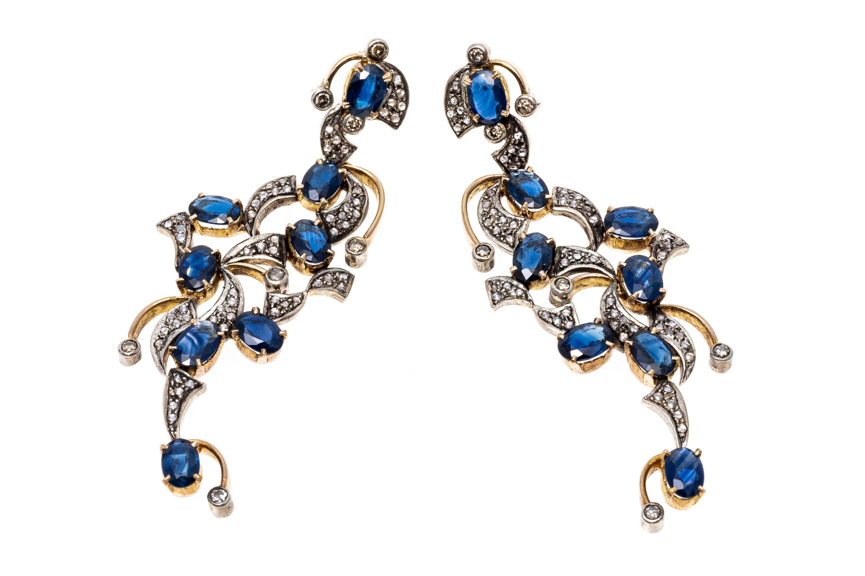 14k and sterling earrings. These striking drop chandelier style earrings feature oval faceted, medium blue color sapphires, approximately 4.80 TCW and prong set, scattered throughout with round faceted diamonds, approximately 0.14 TCW, and macle cut