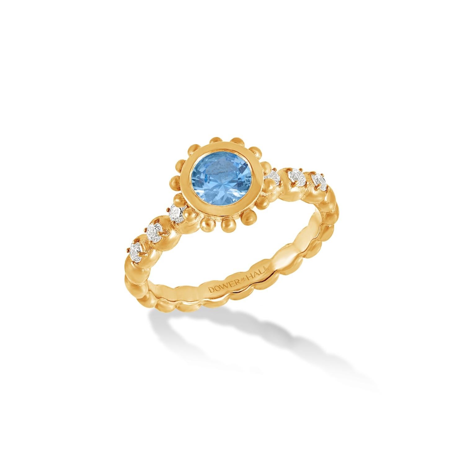 This striking ring is set with a faceted round Blue Topaz in 14k yellow gold featuring granulated balls around the outside of the rub-over setting and with diamonds claw set in the dotty style band. Inspired by creatures of the coral reef, this