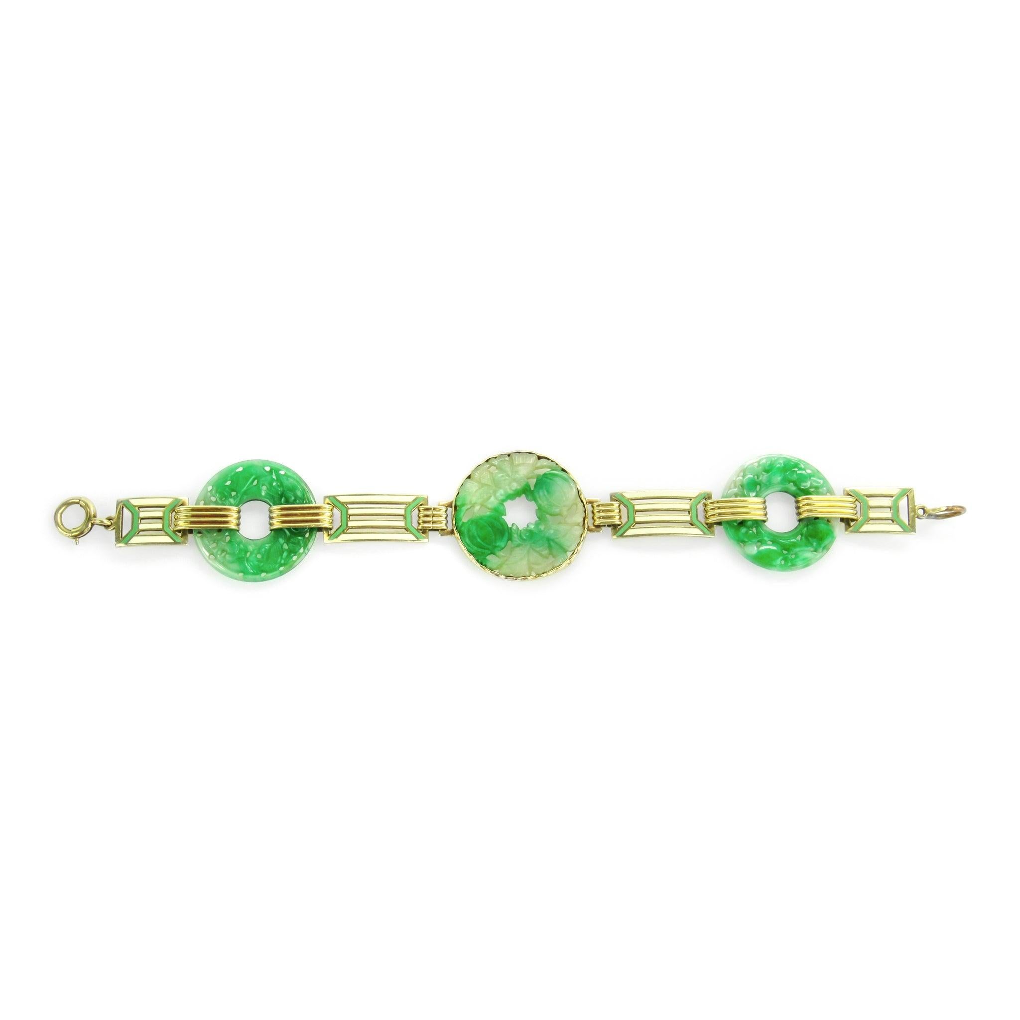 This Art Deco bracelet features three artfully carved jade pi discs connected by geometric links in lime green and white enamel joined by ribbed 14 karat gold links. Signed Wordley, Allsopp & Bliss.

Measurements: 7.5” long by 1 1/8” wide

Condition