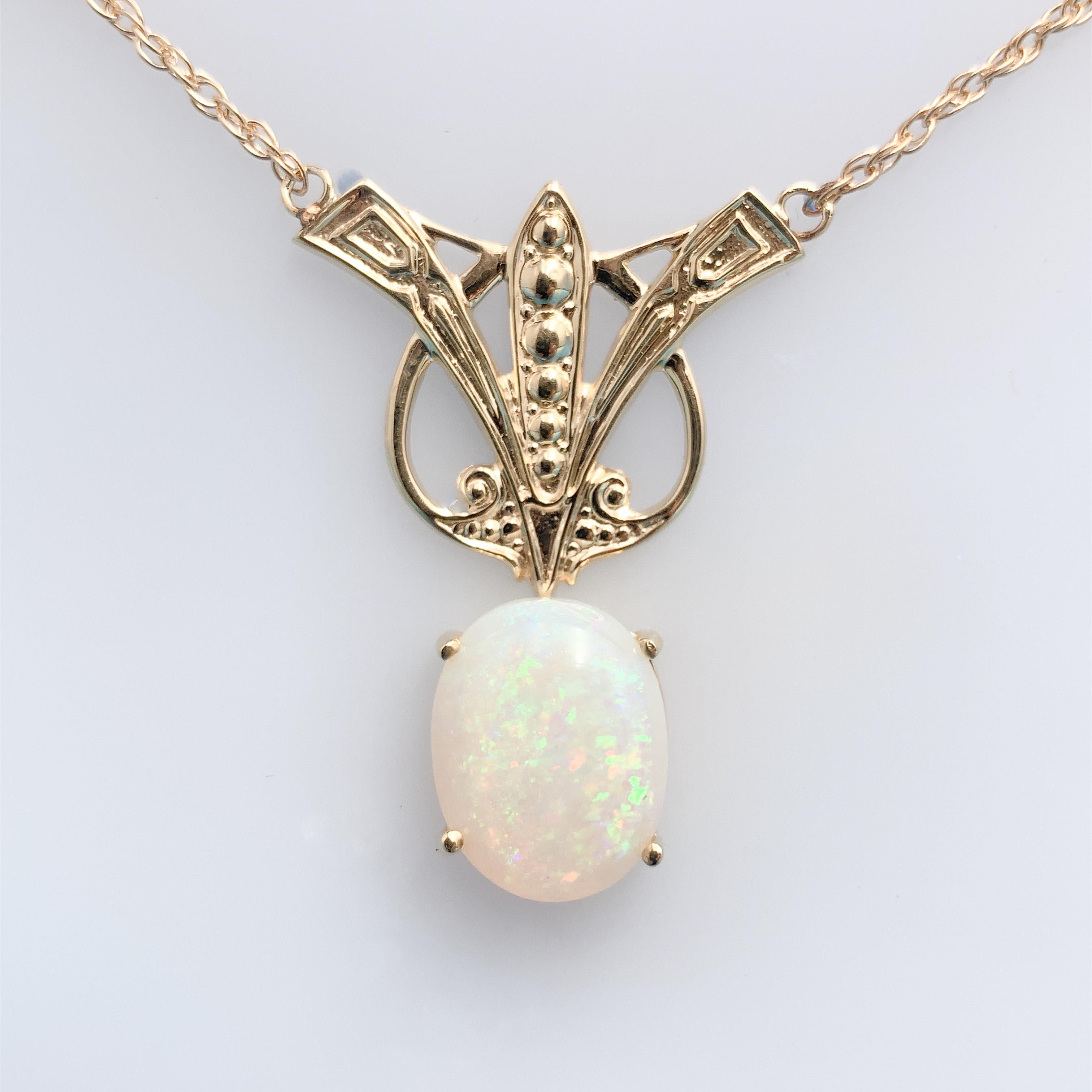 14k yellow gold opal necklace, an Arts & Crafts style casting that is newly made from the antique molds. The Australian opal has beautiful blue-green play of color with pink/red flashes. The oval opal measures about 12.4mm x 15.5mm and weighs 8