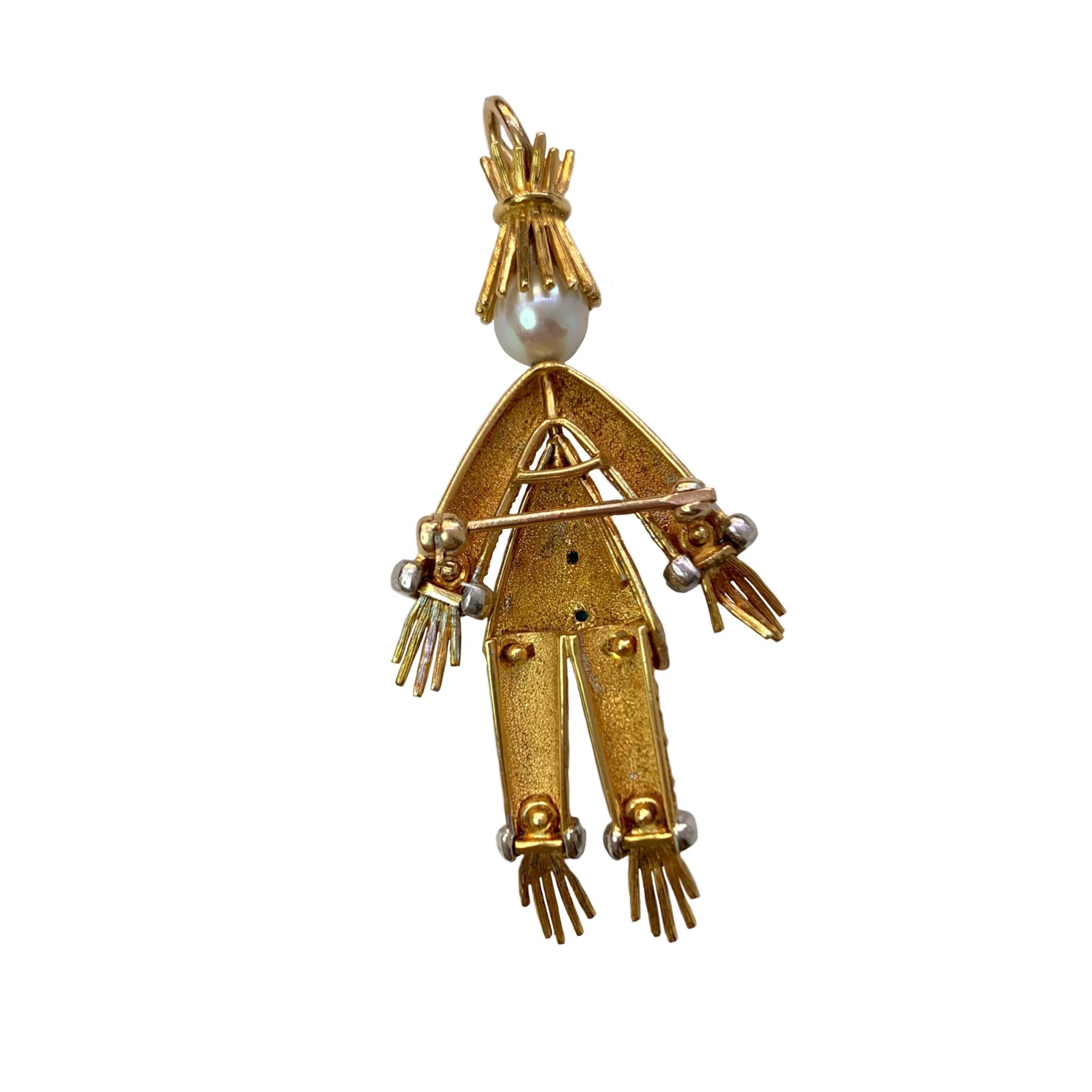 Rudi Cherny designed 18 Karat yellow gold scarecrow pin/pendant embellished by a 6mm cultured pearl head and accented with two 1mm turquoise and 20 single cut diamonds on the wrists and ankles with a total weight of approximately 0.10cts. He is