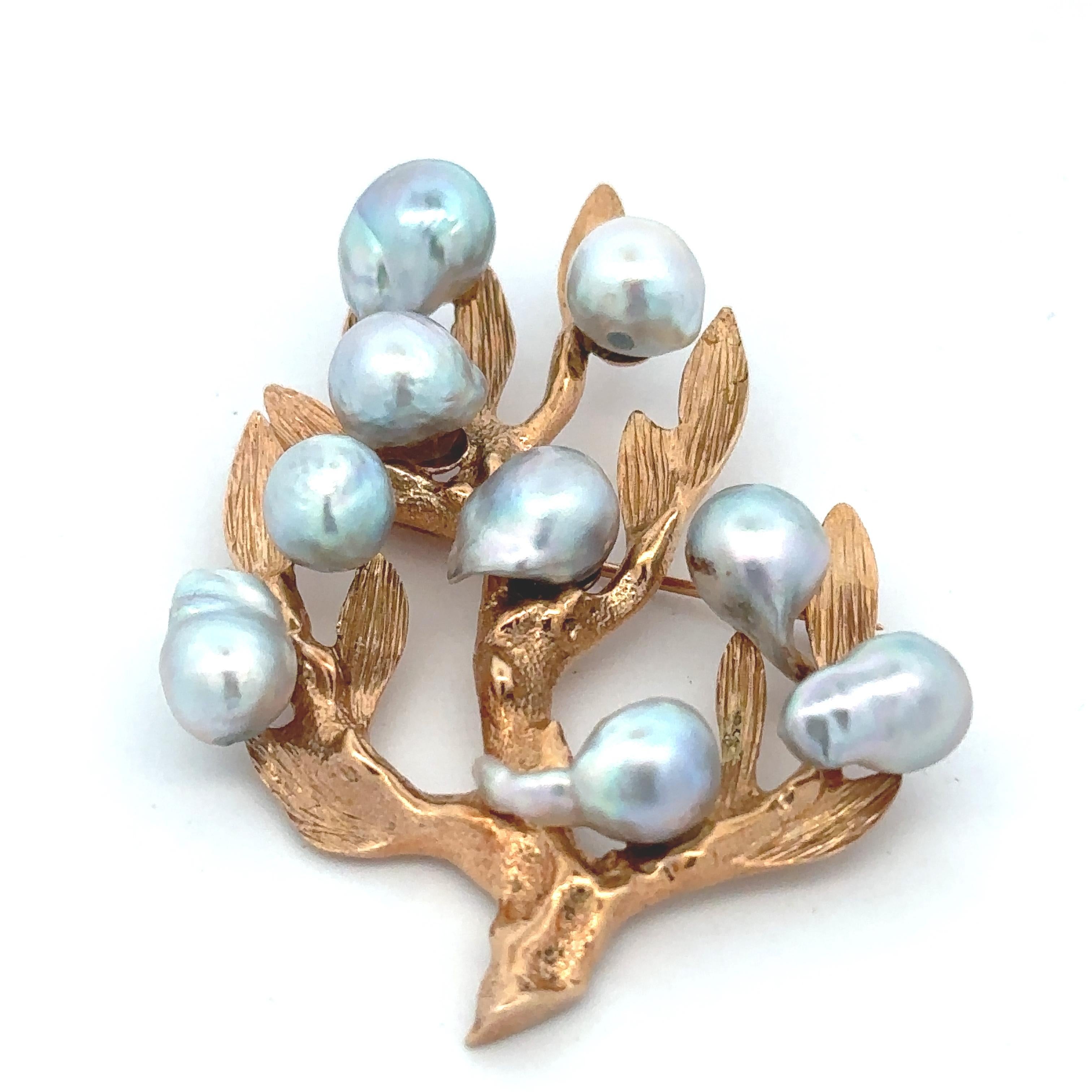 A textured 14k yellow gold branch adorned with natural blue baroque Akoya pearls on a 1 inch pin. The brooch is approximately 2