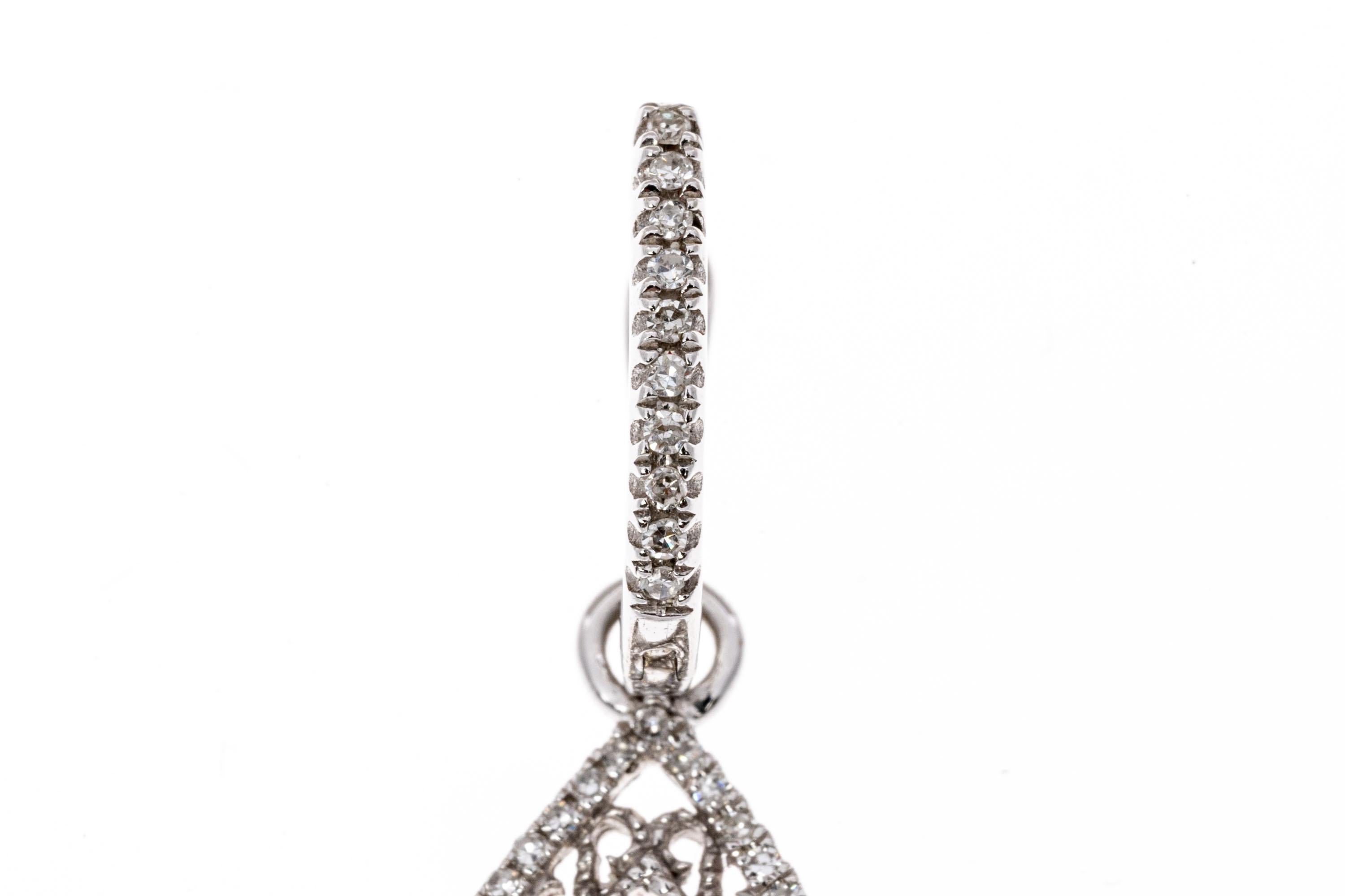 14k white gold earrings. These beautiful, versatile earrings contain a small hoop top, set with a row of round faceted, white diamonds. Suspended from the hoop is a pear shaped open drop style pendant, bordered with a fine filigree edge and trimmed
