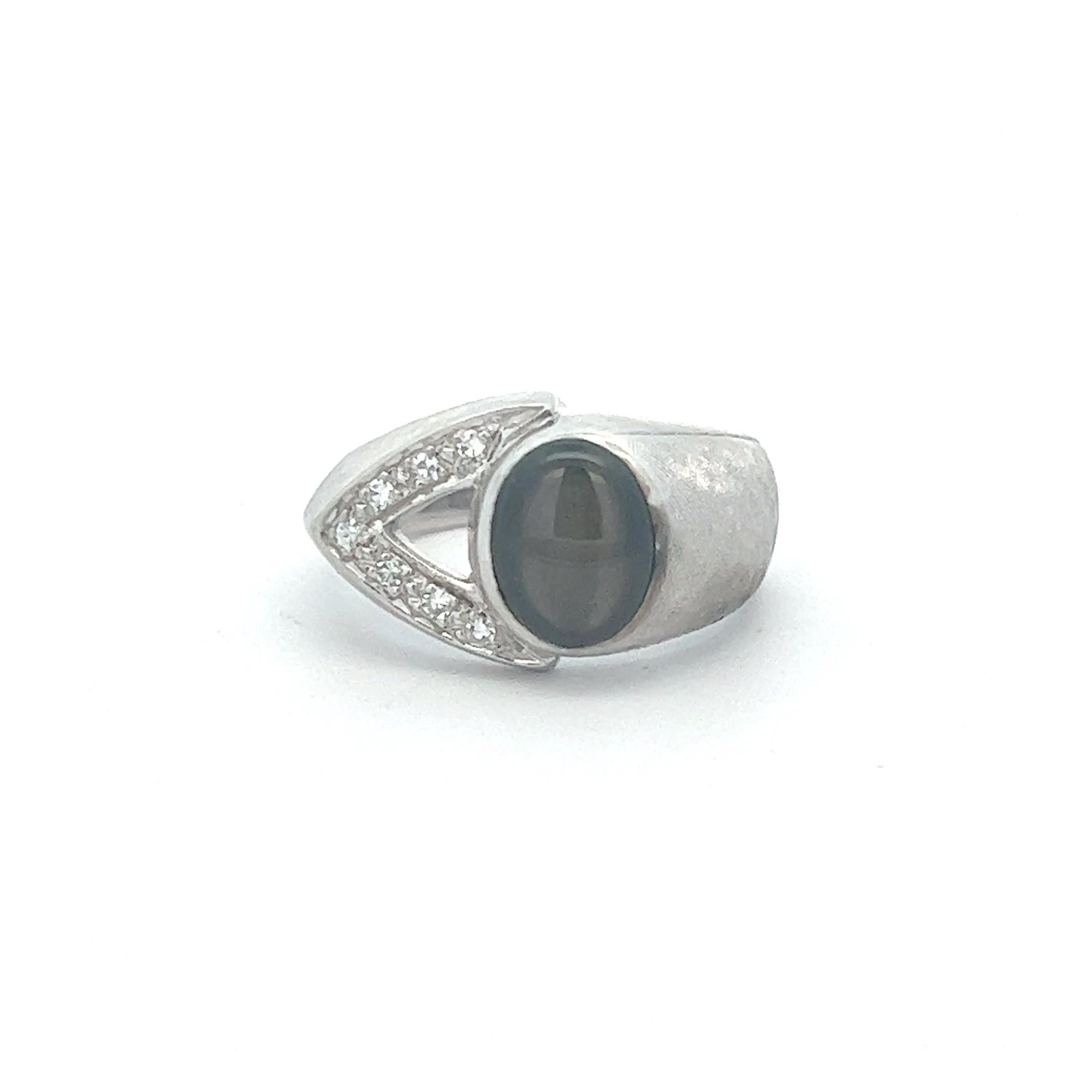 A distinctive modern ring crafted of textured 14k white gold featuring a remarkable black star sapphire with diamonds. The sapphire weighs approximately 2.5 cts and the diamonds are approximately 0.07 ctw (both measurements taken in setting). 