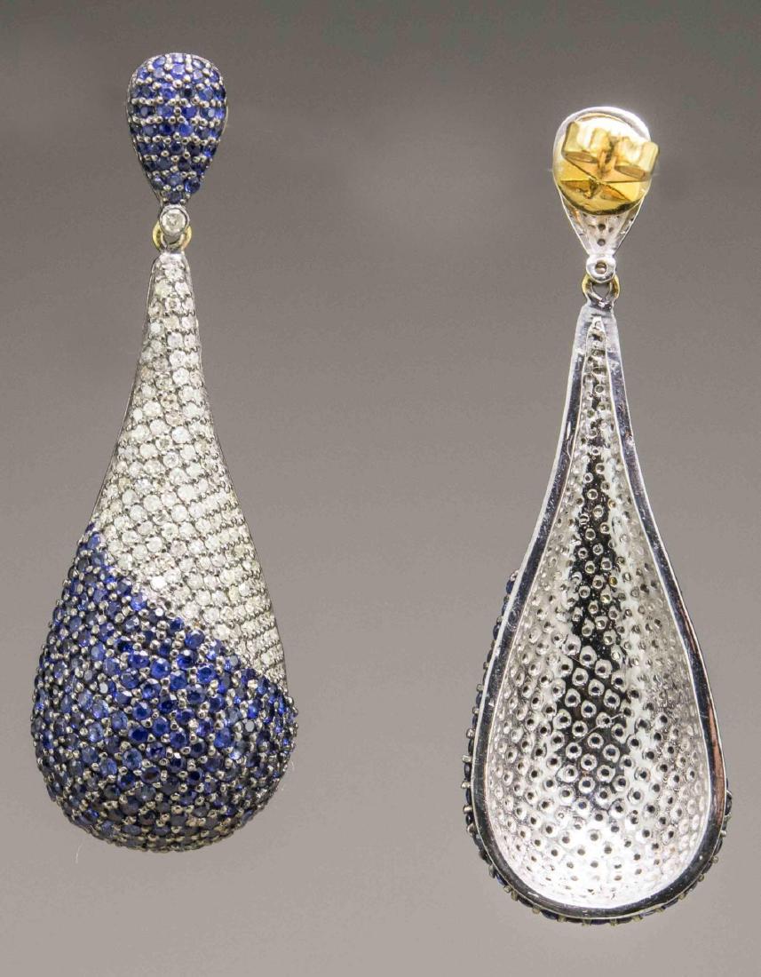 14k blackened gold earrings, designed as pave set elongated teardrops, suspended by blue diamond. Blue diamond total 6.96 carats, white diamonds total 1.72 carats. Length 2 1/8 inches, 14.79 grams.