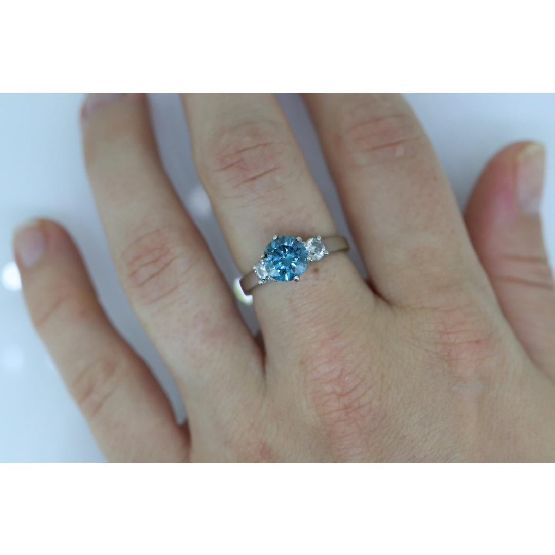 Vintage from the 1980s
Materials: Stone
Gemstone: Diamond
Gem color: Blue
Band Color: White

Style: Minimalist

One of a kind Fancy BLUE color Diamond engagement ring.

Large Blue solitaire in the center with two colorless diamonds on shoulders