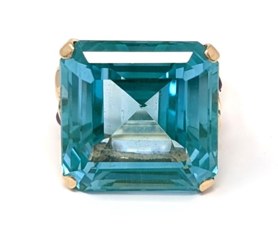Stunning 14k solid yellow gold ring featuring a dazzling square cut topaz center, accented on each side by round cabochon rubies. The centerpiece is a vibrant blue green, the video shows the color best. Best fits for a US size 4.75 finger, the