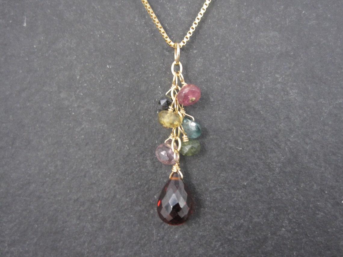 This beautiful vintage gemstone pendant is 14k with natural gemstones.

Measurements: 1 7/16 inches

Comes on an adjustable 14K over sterling silver chain that adjusts from 16 to 18 inches.
This chain is a Roberto Coin product.

Condition: Excellent