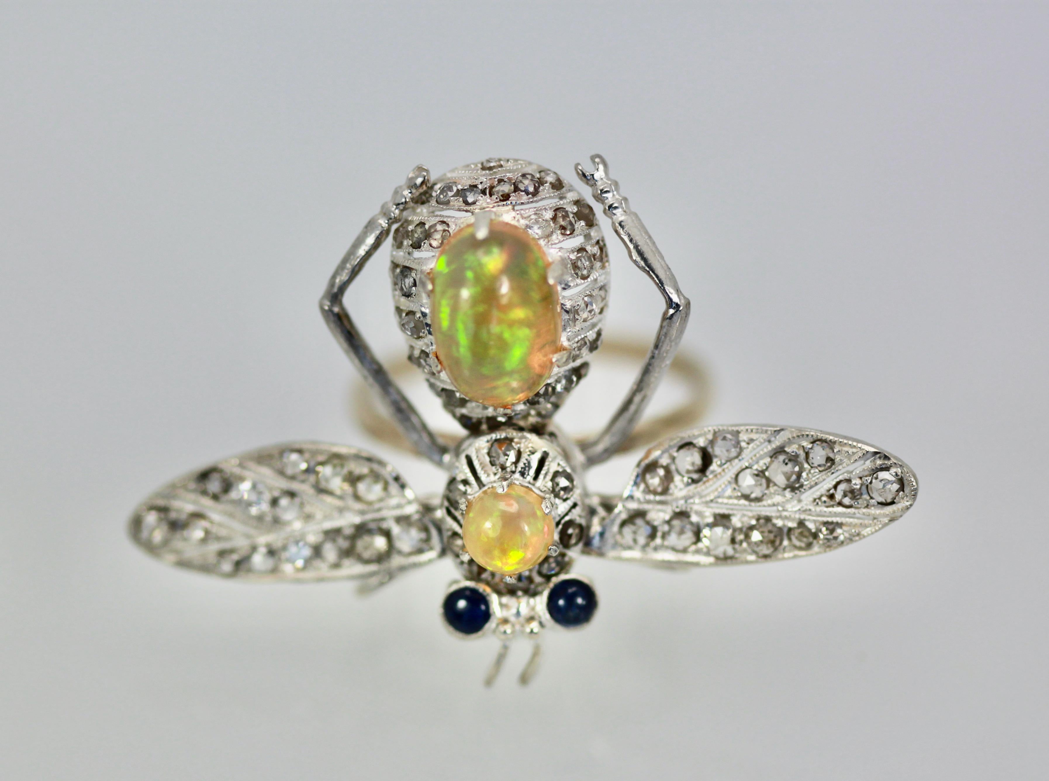 This butterfly is unique as they started out as pins and I turned them into rings.  The wings are set with Diamonds over silver and they move with your hand as they are flying around.  The body is 14K gold and two Jelly Opals form the body and head.