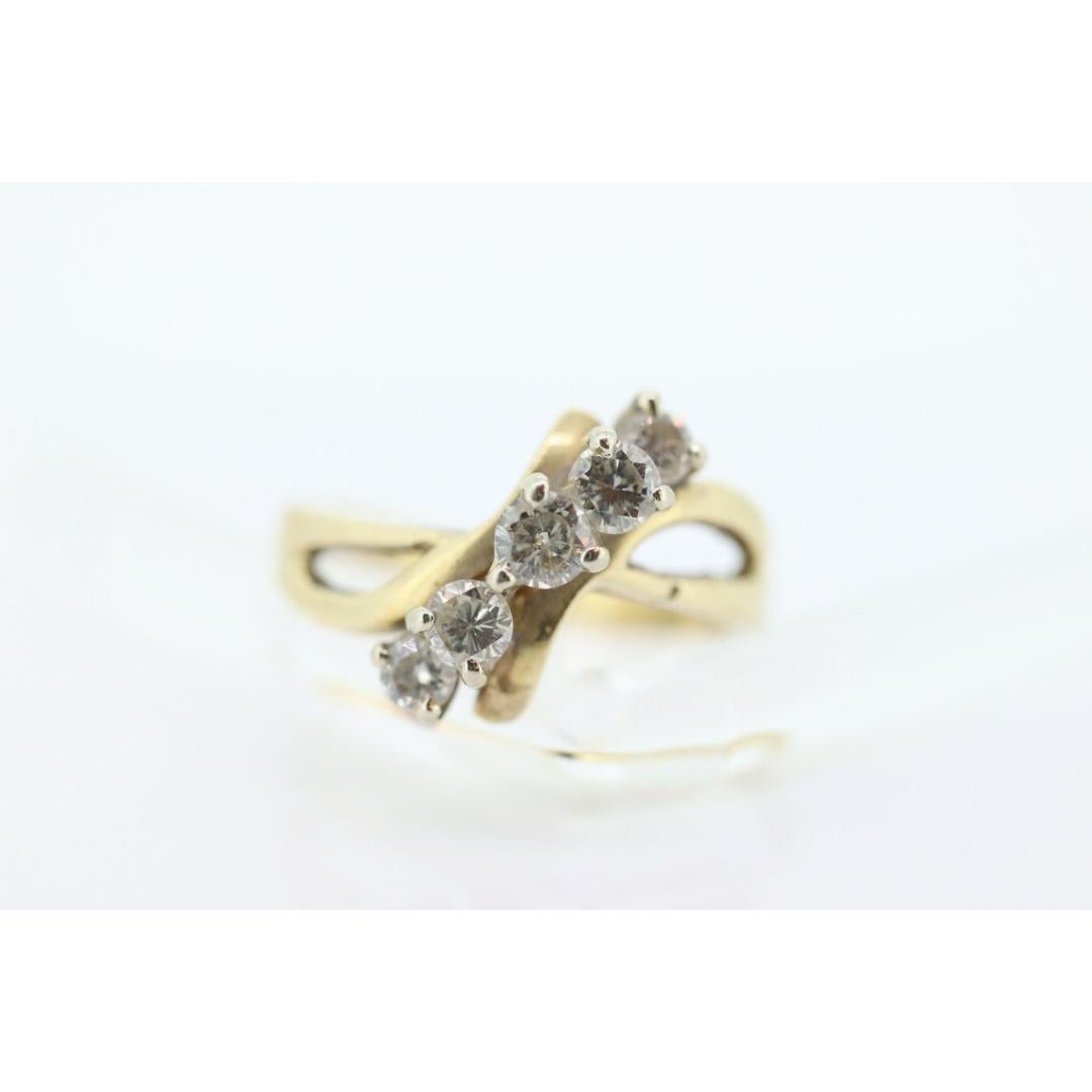 Vintage By aus den 1980er Jahren
MATERIALIEN: Stein
Edelstein: Diamant
Edelsteinfarbe: Farblos
Bandfarbe: Gold

Stil: Avantgarde

Einzigartiger Vintage-Ring. Bypass-Ring im Wellendesign. 5 Diamanten mit einem Durchmesser von 2,8-3,5 mm, gefasst in