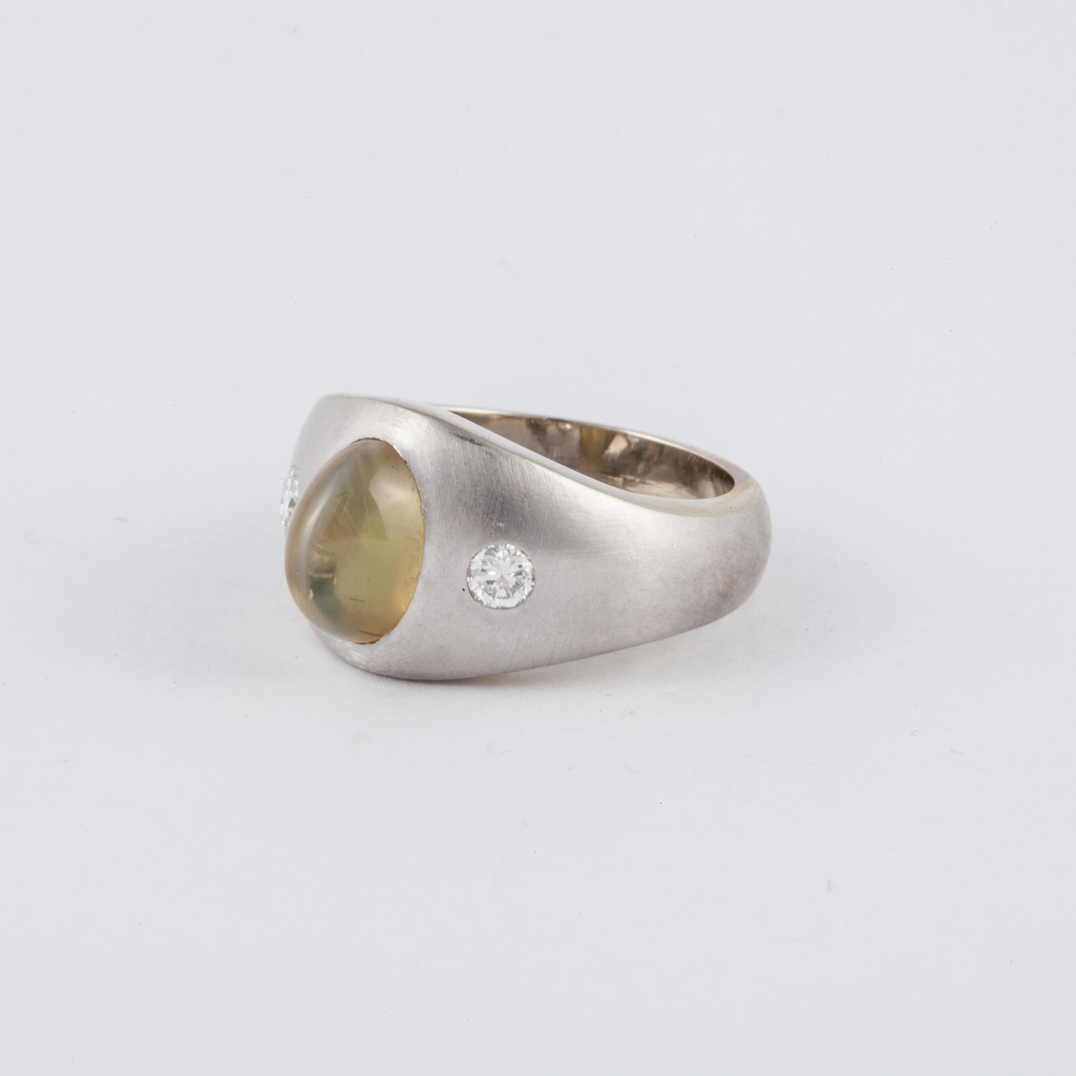 14K white brushed gold ring featuring a 4.70 carat cat's eye chrysoberyl accented by diamonds. The diamonds total 0.28 carats.  Measures 3/4 inches by 1/2 inches and stands 7/16 inches off the finger.