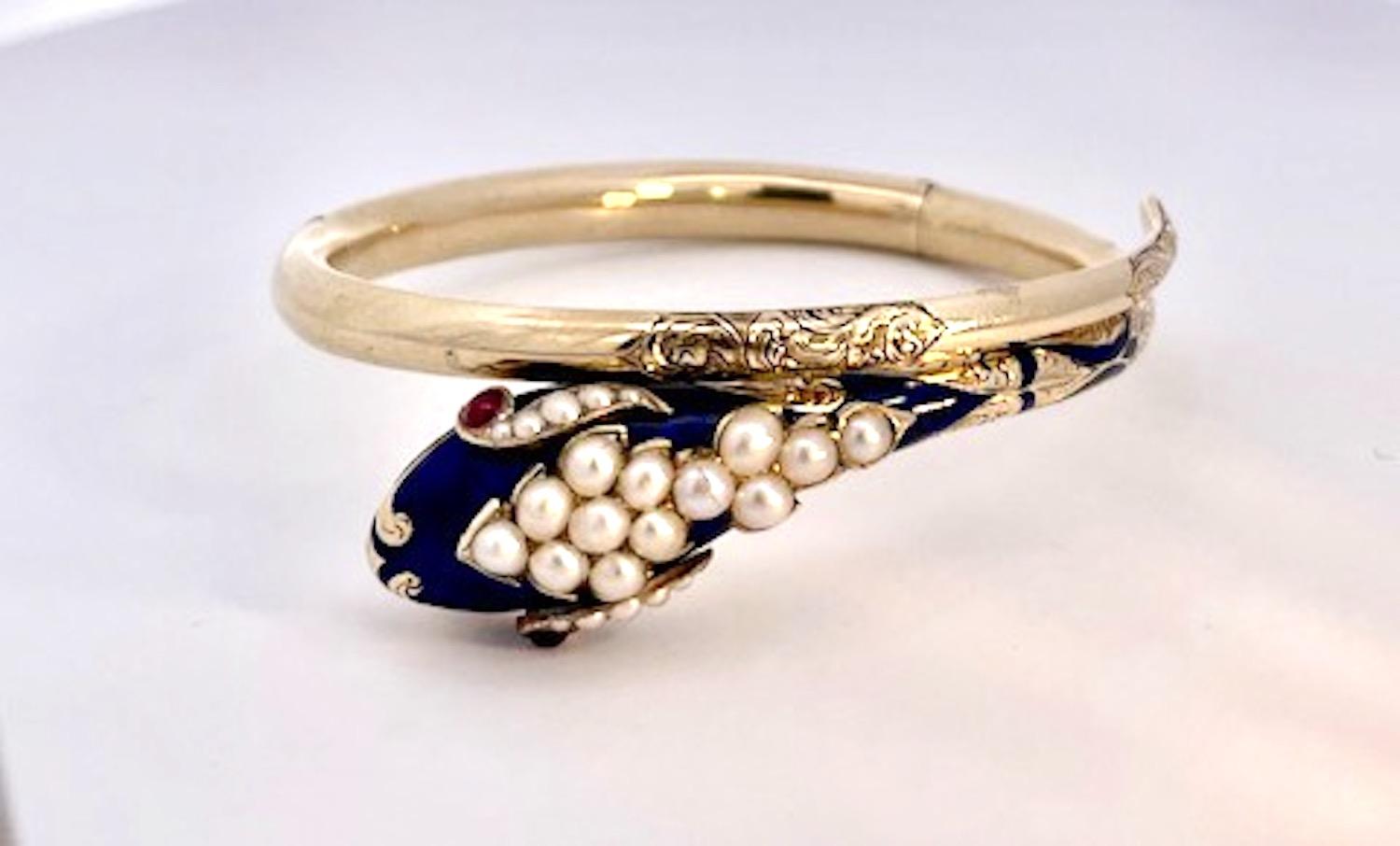 Cet étonnant bracelet serpent en or jaune 14K est très spécial.  Ce bracelet est réalisé en émail bleu cobalt, or gravé et yeux de rubis.  La tête est ornée de treize perles de 0,15 mm chacune et, à côté des yeux en cabochon de rubis, de cinq perles