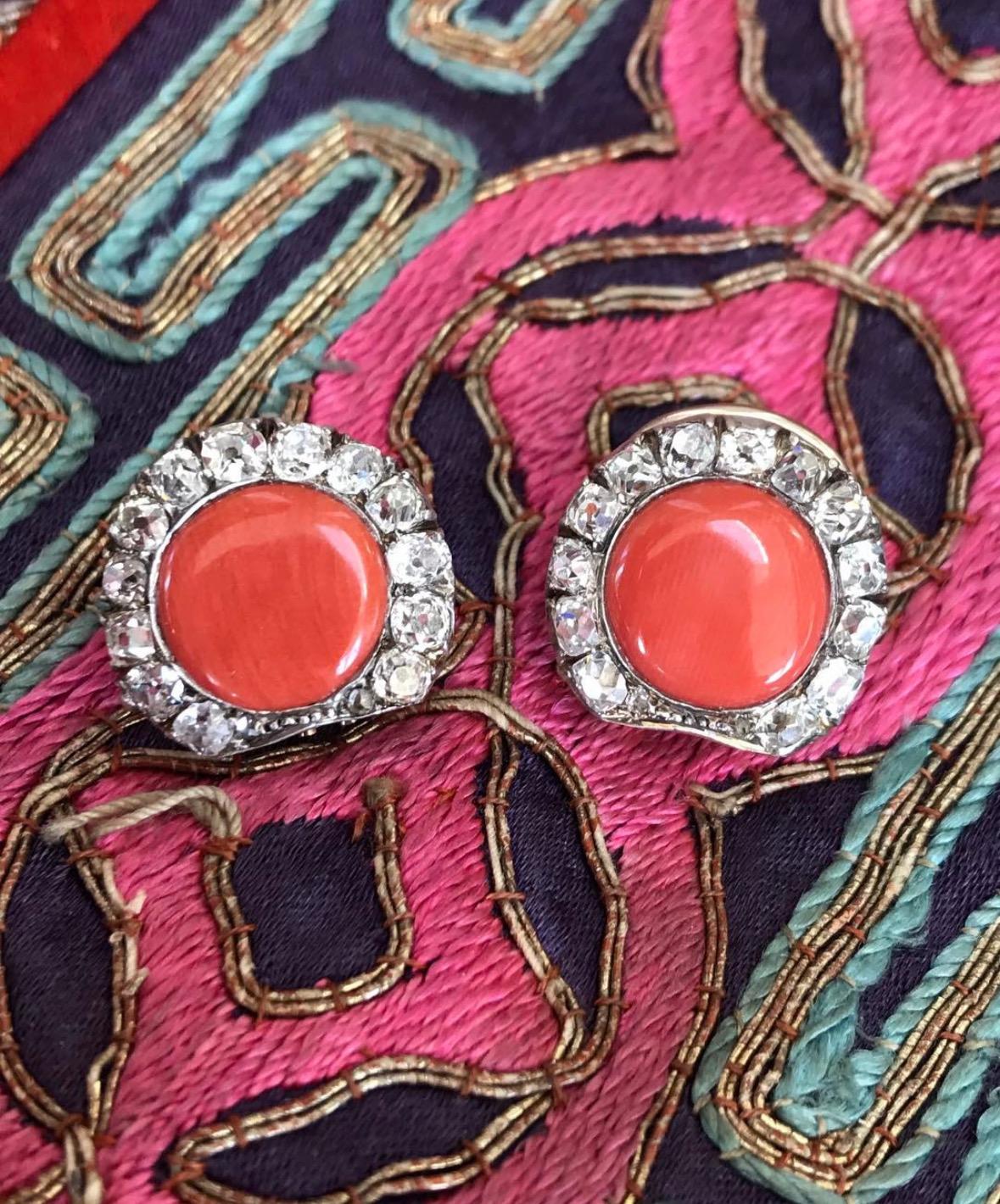 Perfect of summer, this lovely pair of antique coral conversion earrings features a flat, 11 mm coral disk surrounded by border of glittering cushion cut diamonds. Fabricated in silver topped 14 karat gold. 

Notes: It is likely that these earrings
