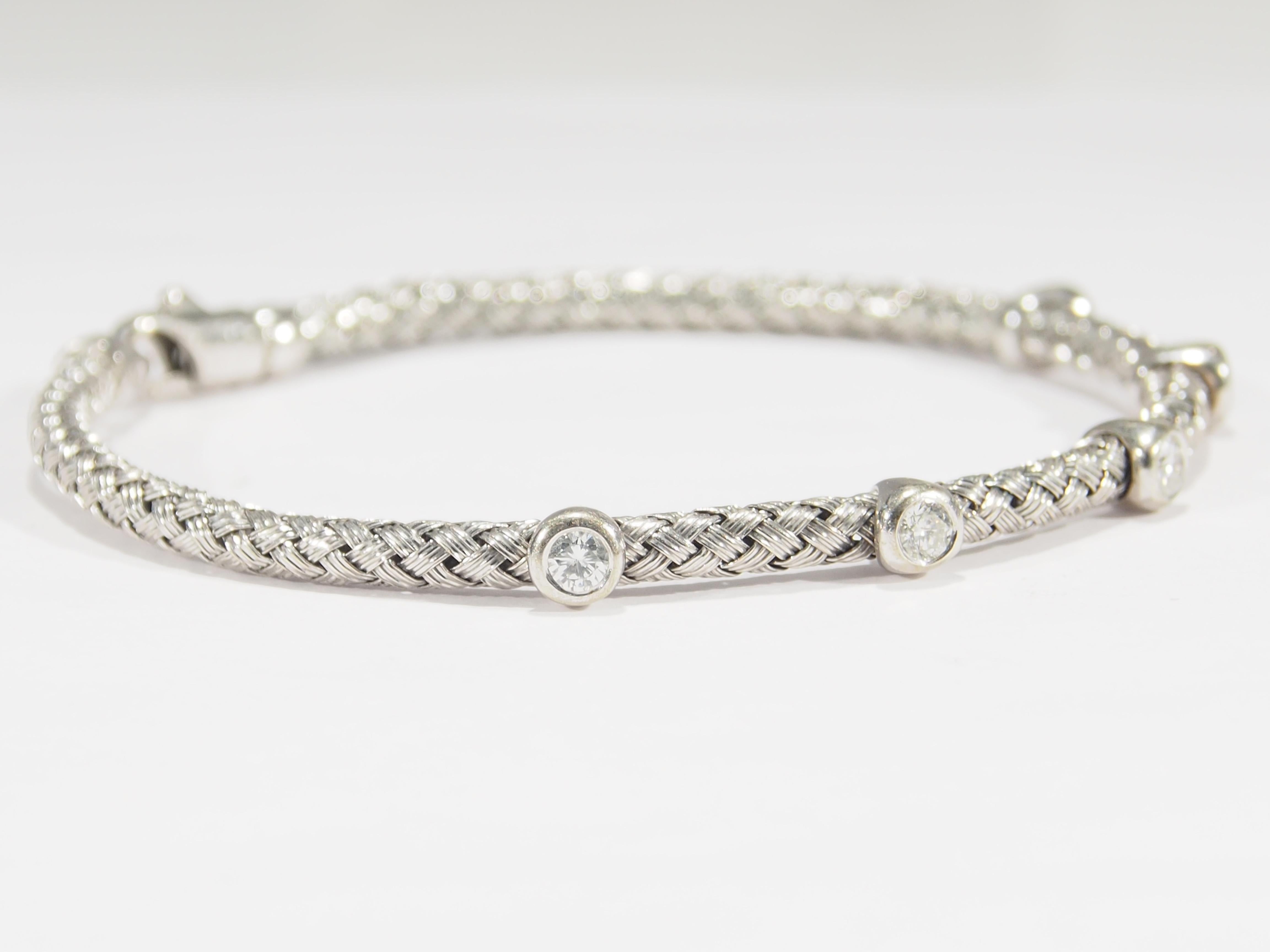 An Italian 14K white gold Rope bracelet with (5) Bezel set Round Brilliant Cut diamonds H-I in color, SI1-I1 in clarity and approximately 0.75 total weight. 7 inch inner circumference, approximately 3.5mm gauge, Lobster Claw closure. 9.17g.