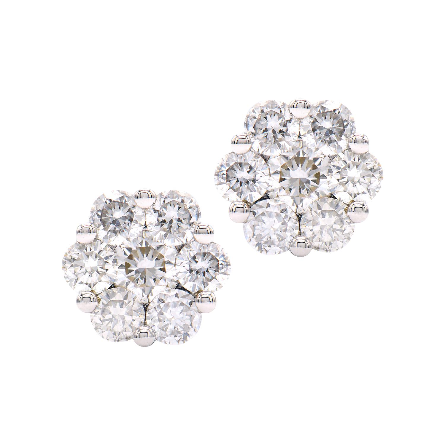 These beautiful diamond cluster earrings are made from 1.4 grams of 14k white gold. There are 2 larger diamonds in the centers that total 0.15 carats and they are surrounded by 12 smaller diamonds totaling 0.44 carats. These earrings have a post and