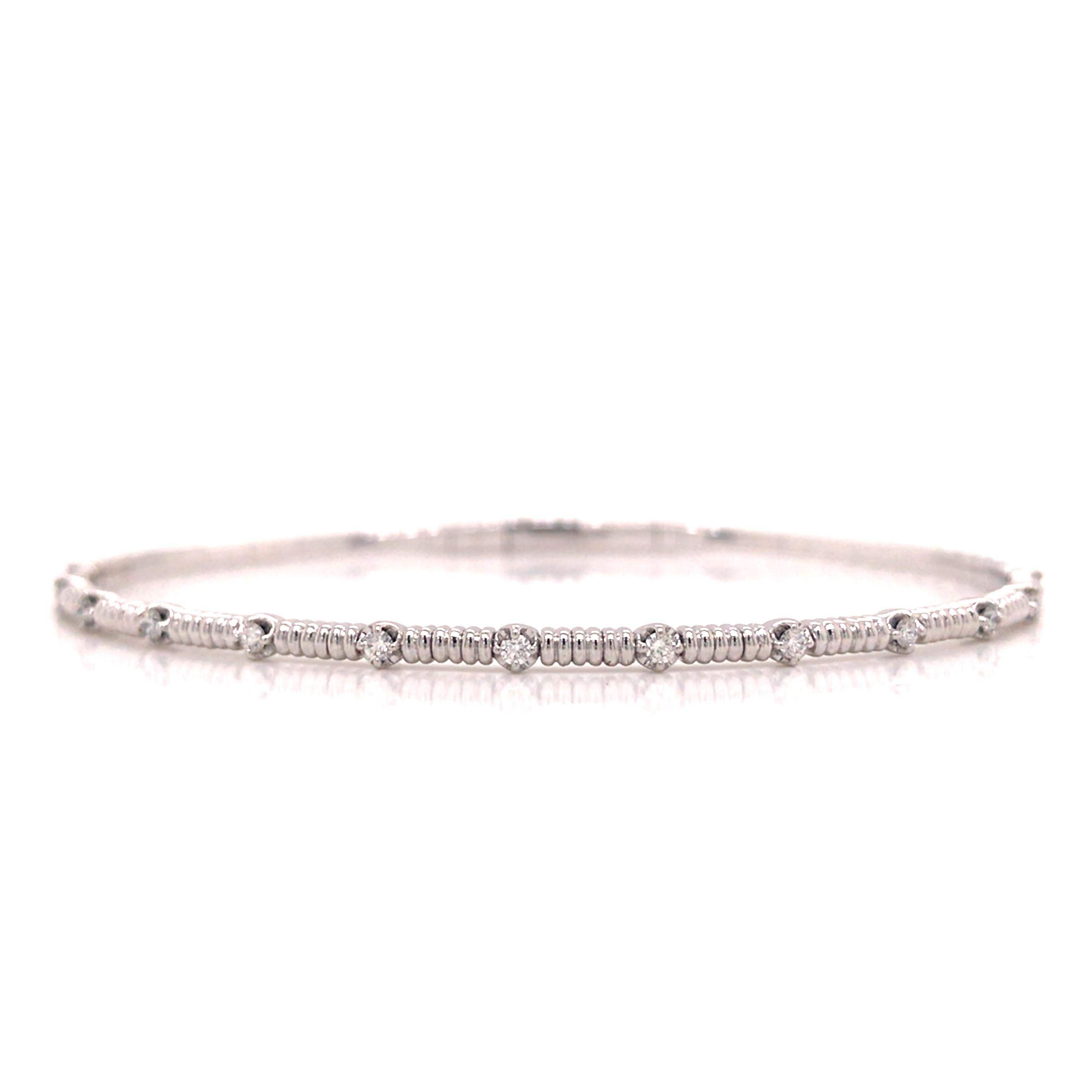 Diamond Flexible Bangle in 14K White Gold.  Round Brilliant Cut Diamonds weighing 0.20 carat total weight, G-H in color and VS-SI in clarity are expertly set.  The Bangle measures 6 1/2 inch and 1/16 inch in width.  5.59 grams.