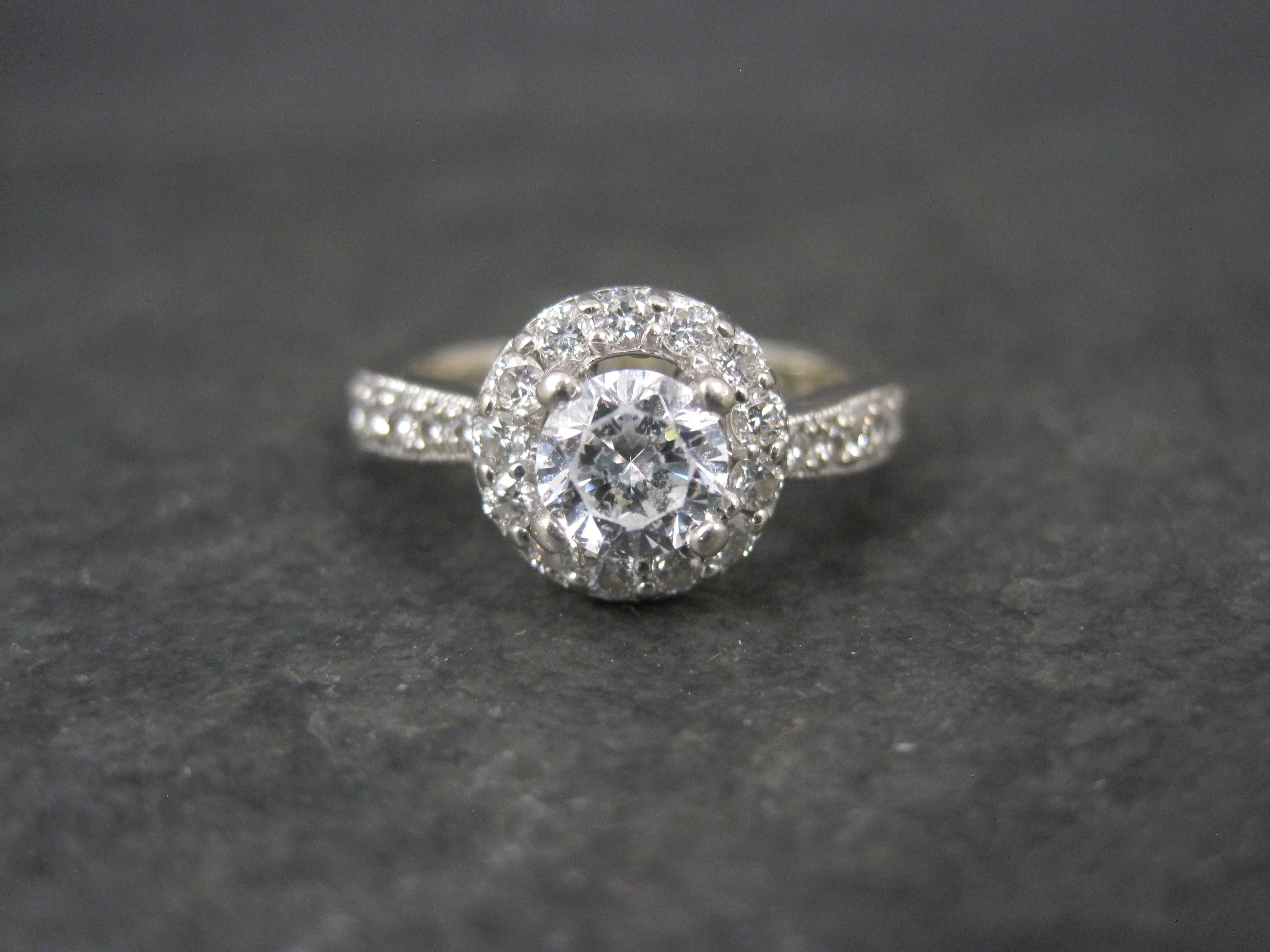 This beautiful engagement ring is 14k white gold.
The semi mount is a product of Finelli.

The center stone is a 5mm cubic zirconia.
The halo and side stones are 1/3 ctw in natural round brilliant cut diamonds estimated to be G to H in color and VS