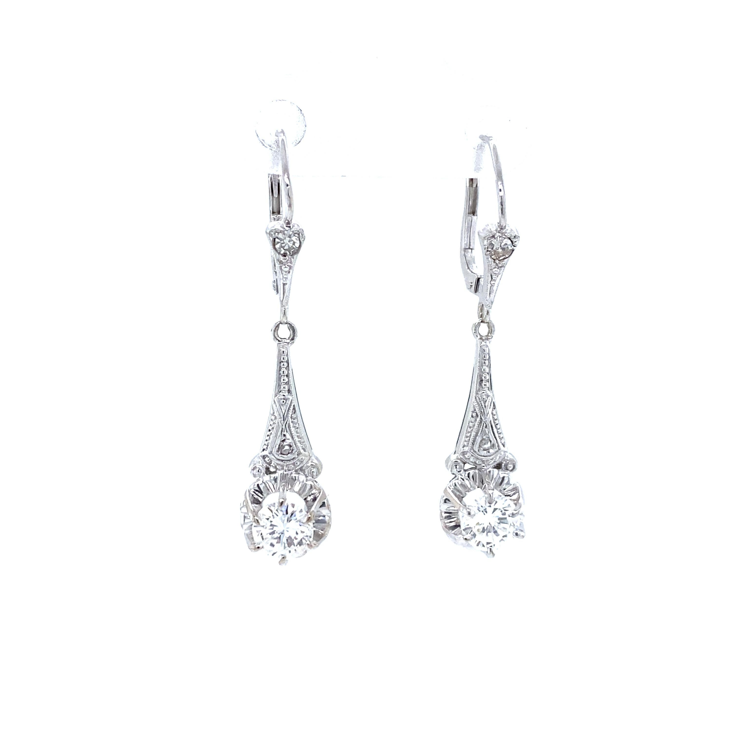 Diamond Hanging Earrings in 14K White Gold.  (6) Round Brilliant Cut Diamonds weighing 0.90 carat total weight, G-H in color and SI-I1 in clarity are expertly set.  The Earrings measure 1 3/8 inch in length and 5/16 inch in width at the widest
