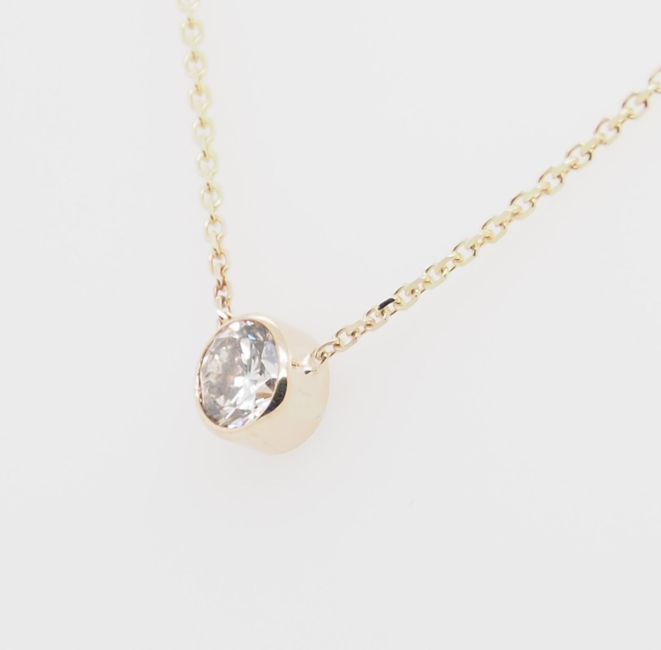A classic bezel set solitaire Pendant in 14K yellow gold. (1) Round Brilliant Cut Diamond .40 carat total weight I-J in color and SI in clarity set in a bezel on a 16 inch 1.1mm cable link chain.  Approximately 1.6 grams, 2/8 inch diameter.