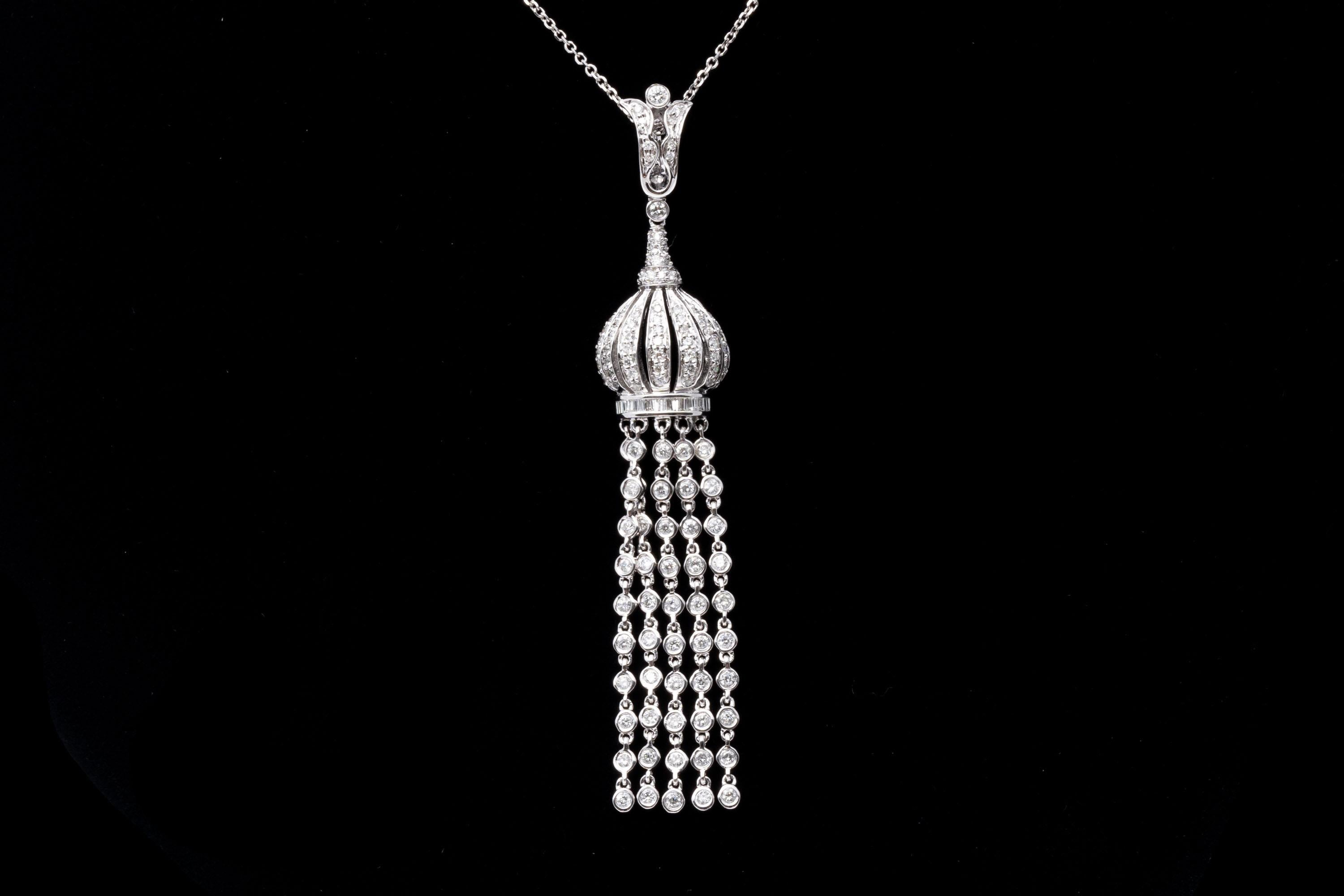 14K white gold and diamond necklace and pendant. A delicate chain supports a lavish and lively pendant with diamonds set tassels below a balloon-style top. The pendant's bail is hinged with a safety latch, allowing it to be set onto a variety of