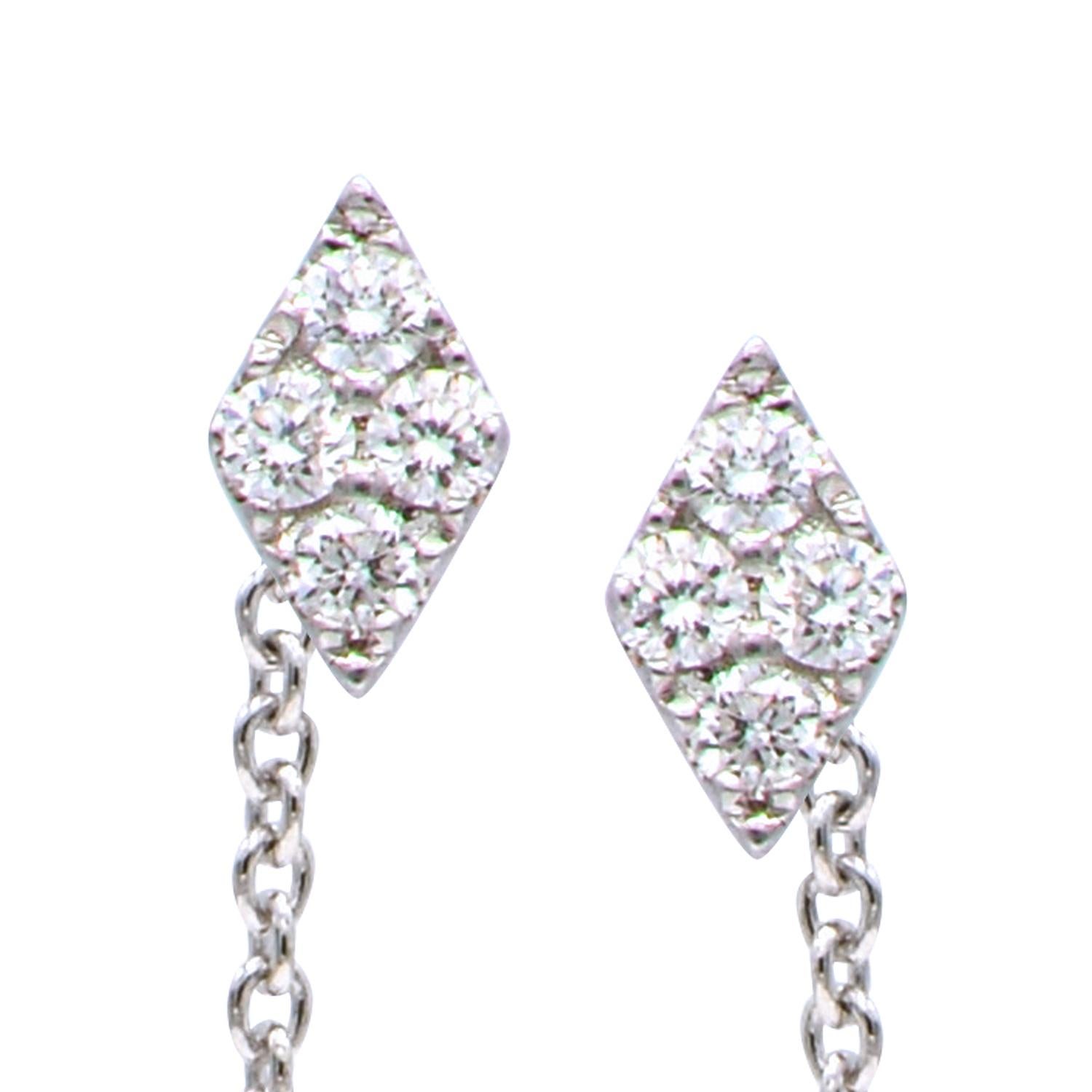 These fun modern earrings are made from 0.9 grams of 14 karat white gold. They have a post and chain that threads through the ear and hangs in the back and is finished with a diamond shape stud that contains 8 diamonds totaling 0.14 carats. These