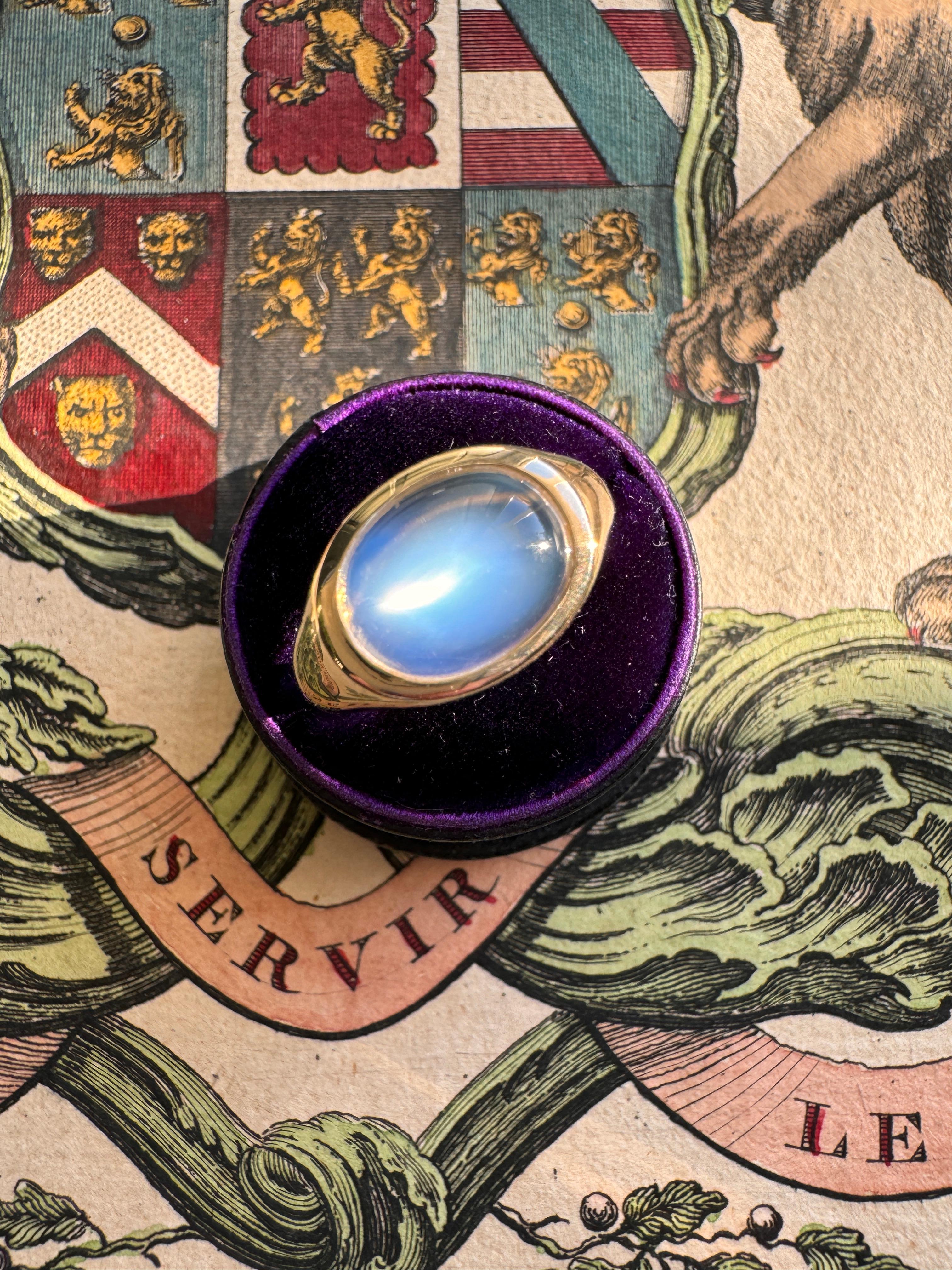 This enchanting antique cabochon moonstone showcases a mystical blue sheen, set within a custom 14k gold east-west setting.

 

Size: 6

Moonstone: antique 11 x 8 3.75 mm

Weight: 5.2 grams

Measurements: 10.9 north to south, sits 4 mm off of the