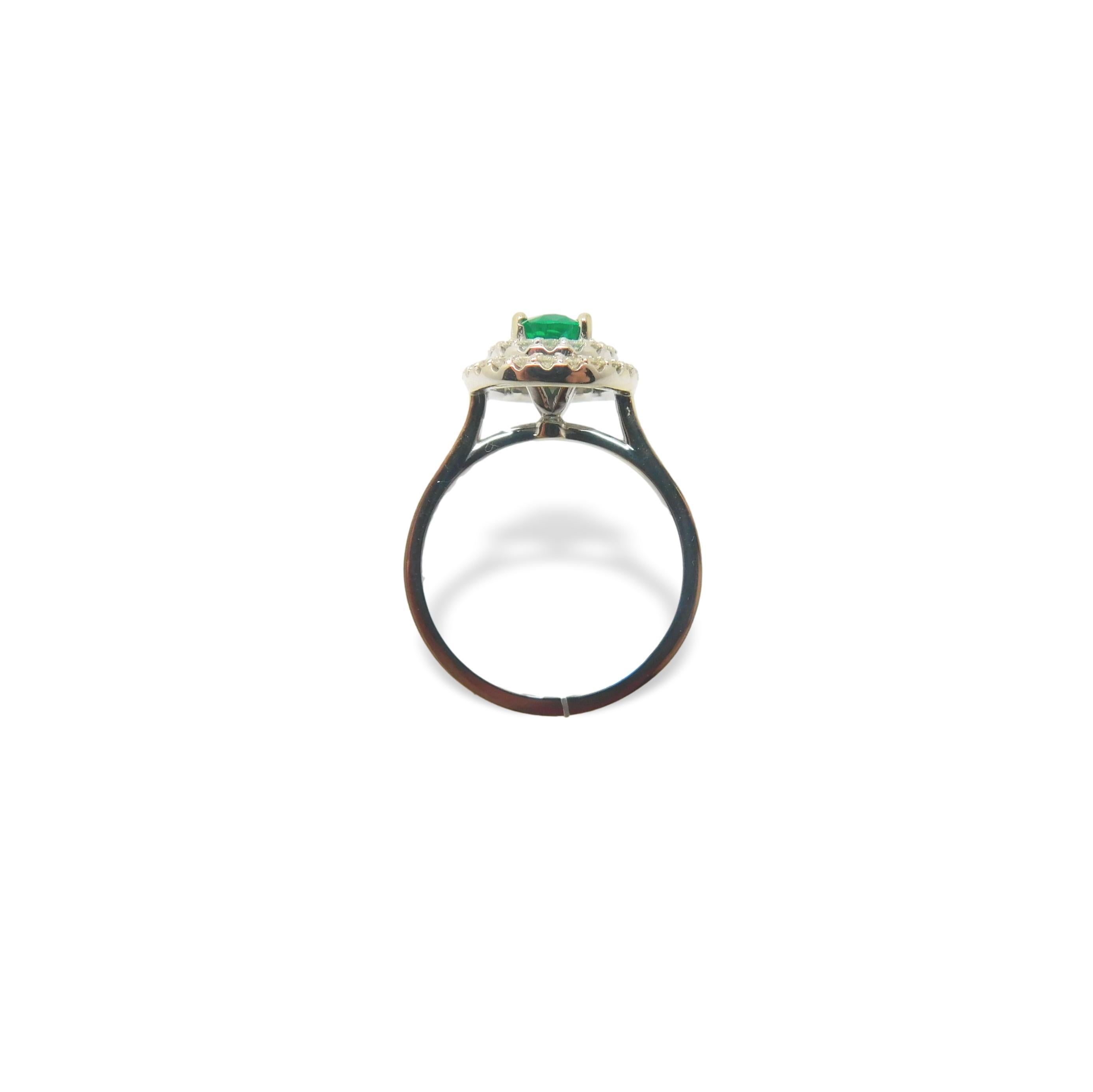 14K white gold ring featuring a fine bright grass green Emerald surrounded by a halo of diamonds.  The oval emerald weighs .76cts and measures about 7.2mm x 4.8mm.  The double halo contains 42 round diamonds that weigh a total of .50cts total and